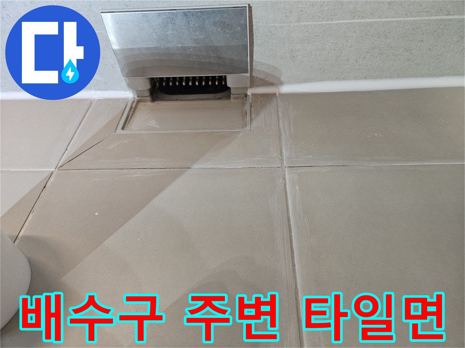 바닥 타일과 배수구 덮개가 맞물린 부위의 근접 사진
