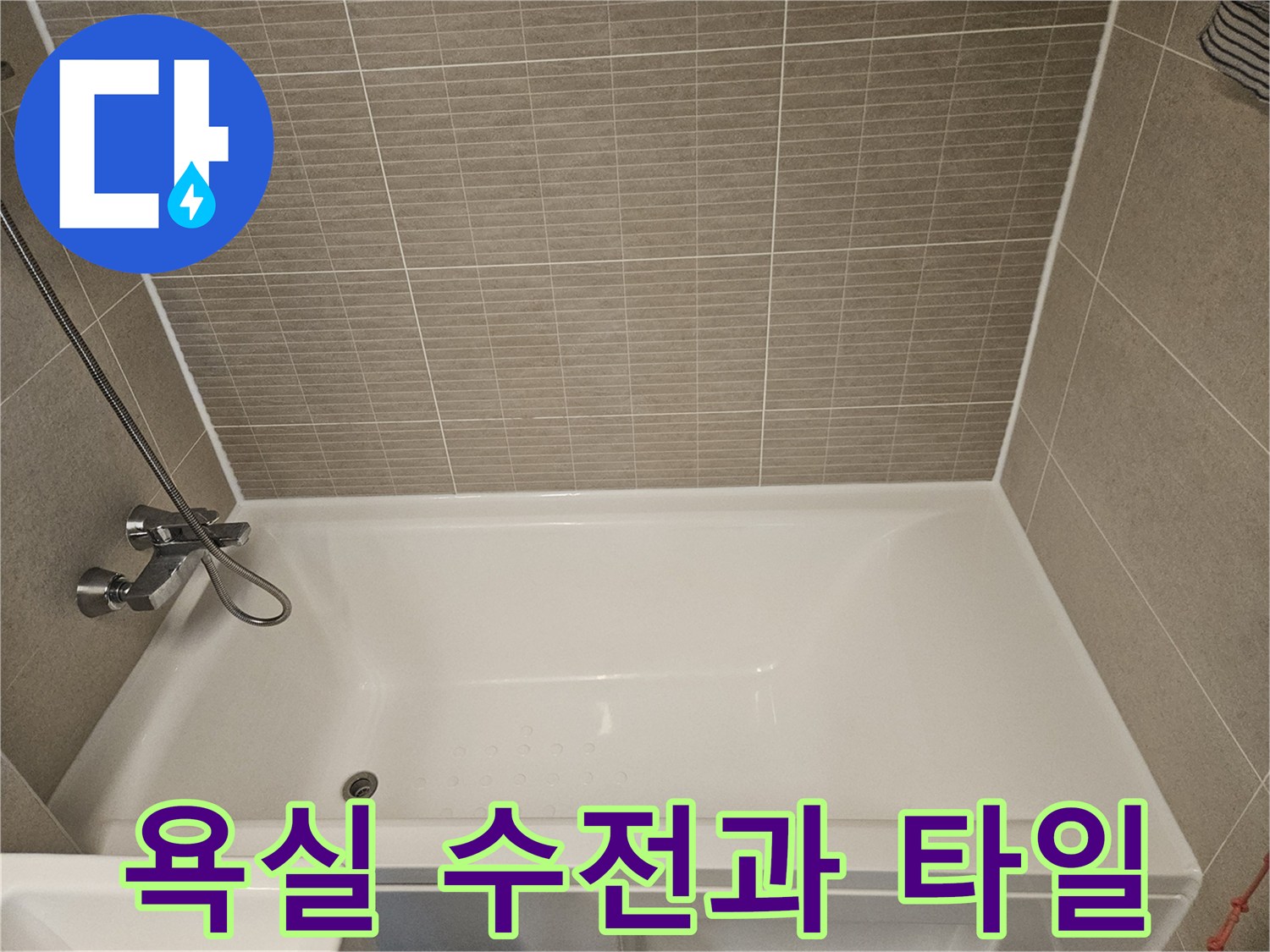 벽면 타일 아래 설치된 금속 소재의 수전 사진