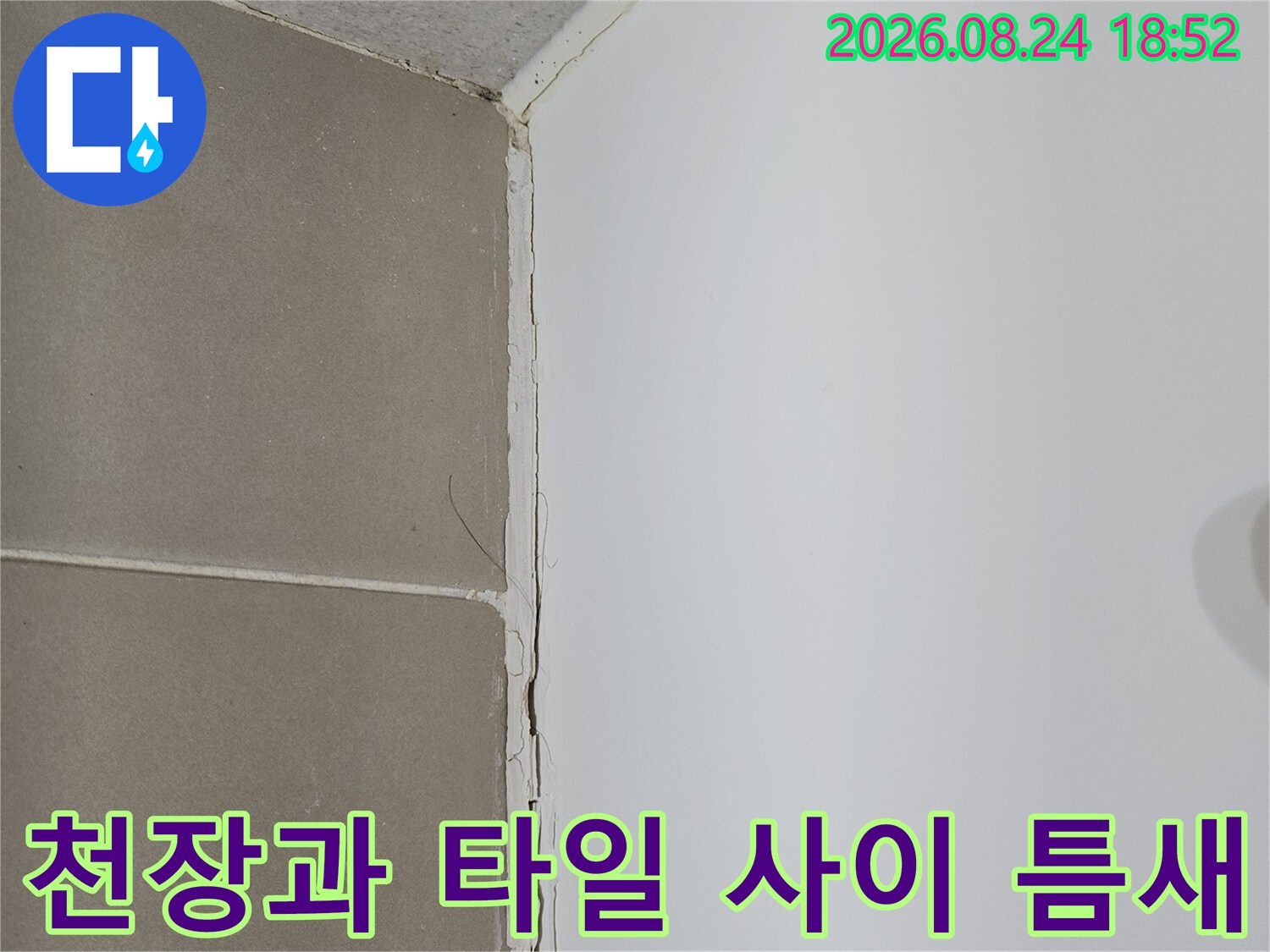 화장실 천장과 타일의-벌어진 경계 부분을 보여주는 사진입니다.