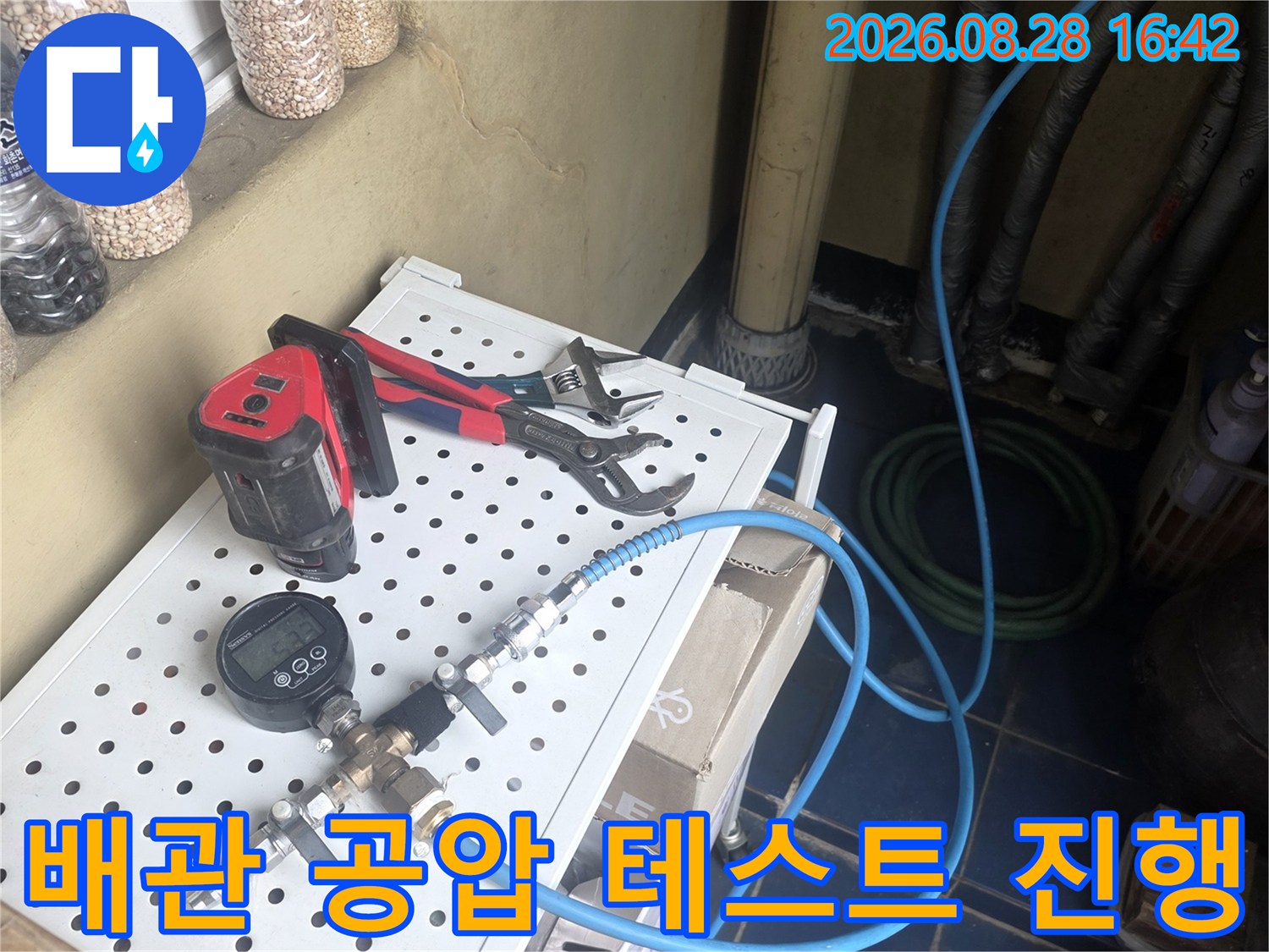 게이지와 호스가 연결된 배관 누수 정밀 검사 장면