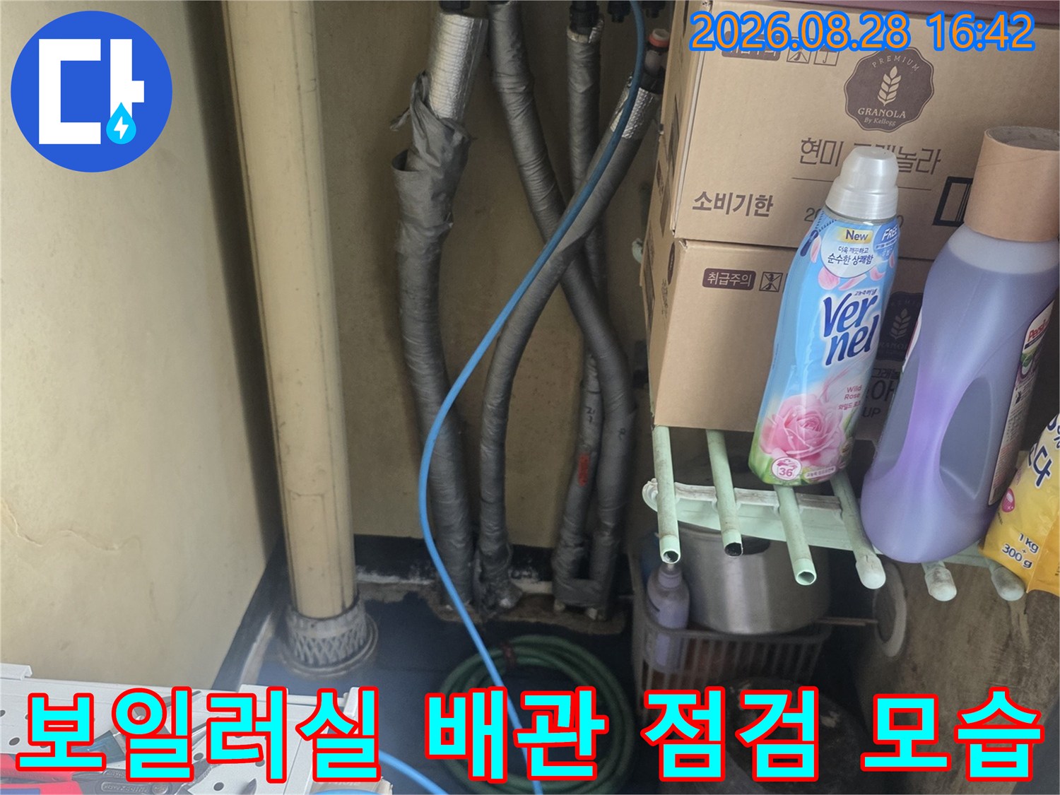 보일러 하단부에 겹쳐진 여러 개의 배관과 점검 장비들