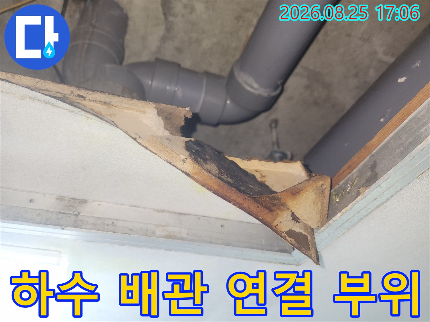 천장 내부의 회색 하수 관로와 손상된 마감재 부위