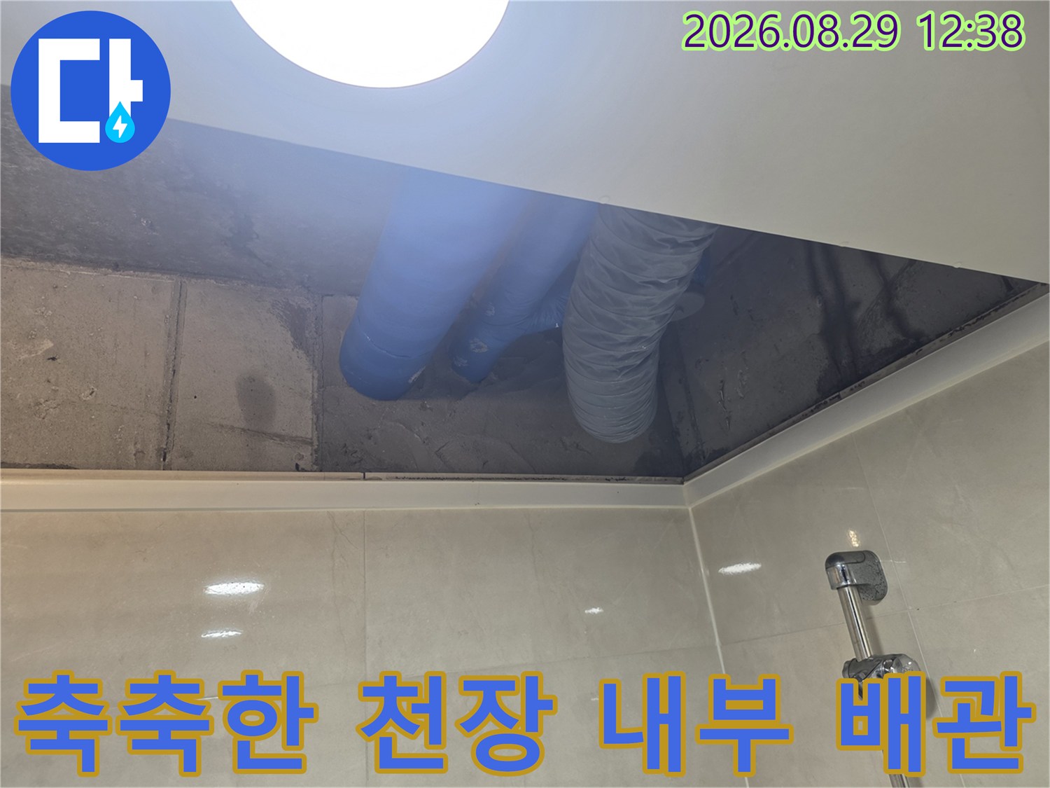 파란색 배수관과 습기가 찬 화장실 천장 내부 모습
