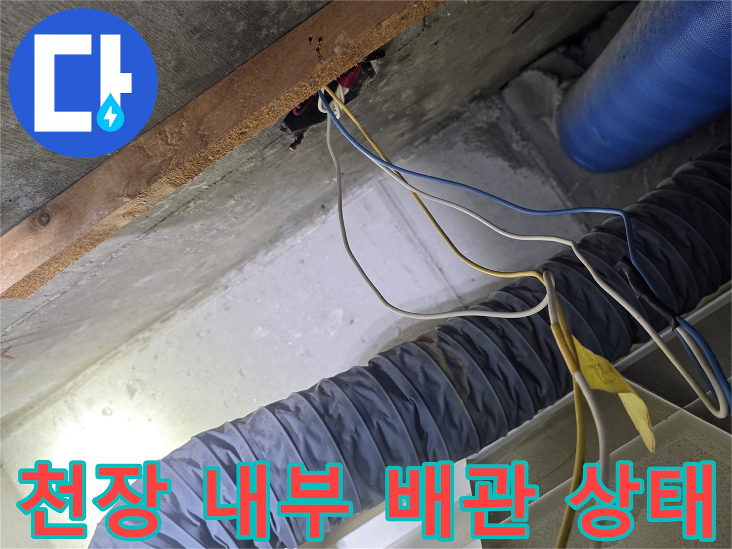 파란색 보온재가 씌워진 배관과 천장 구조물 근접 촬영