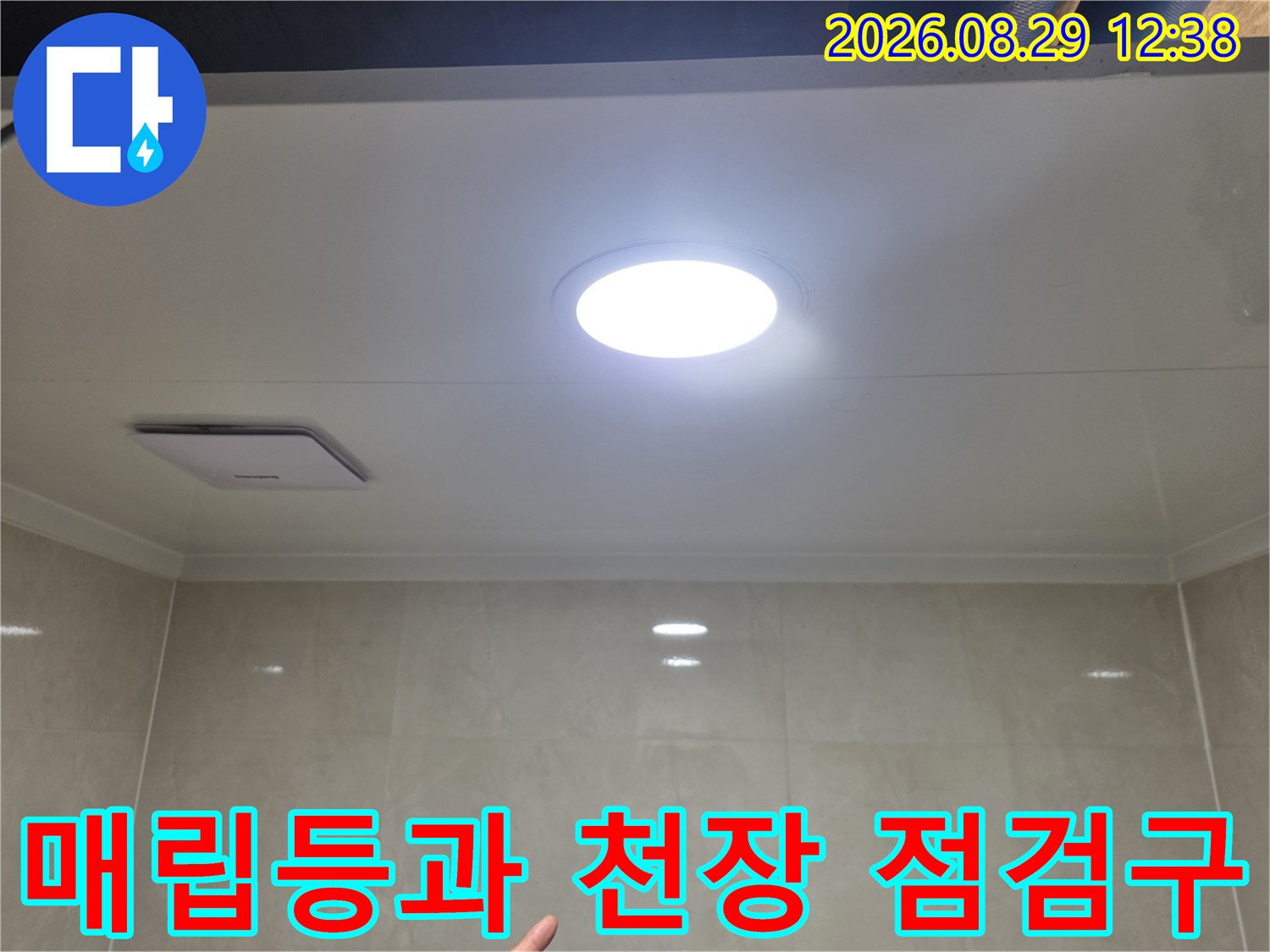 화장실 천장에 설치된 매립형 조명과 점검구 모습