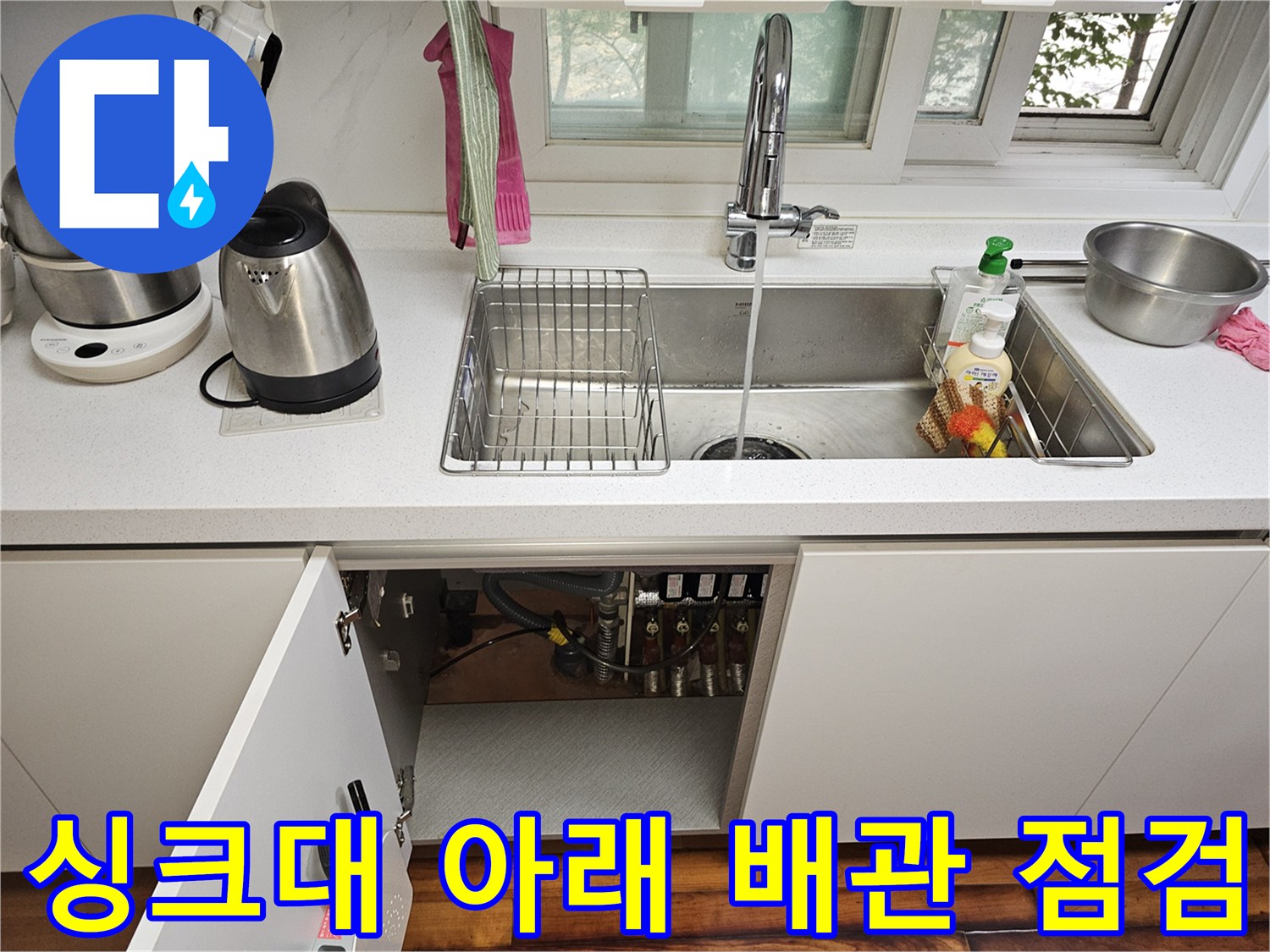 싱크대 하부장 내부의 복잡한 수도 배관 및 밸브 부위