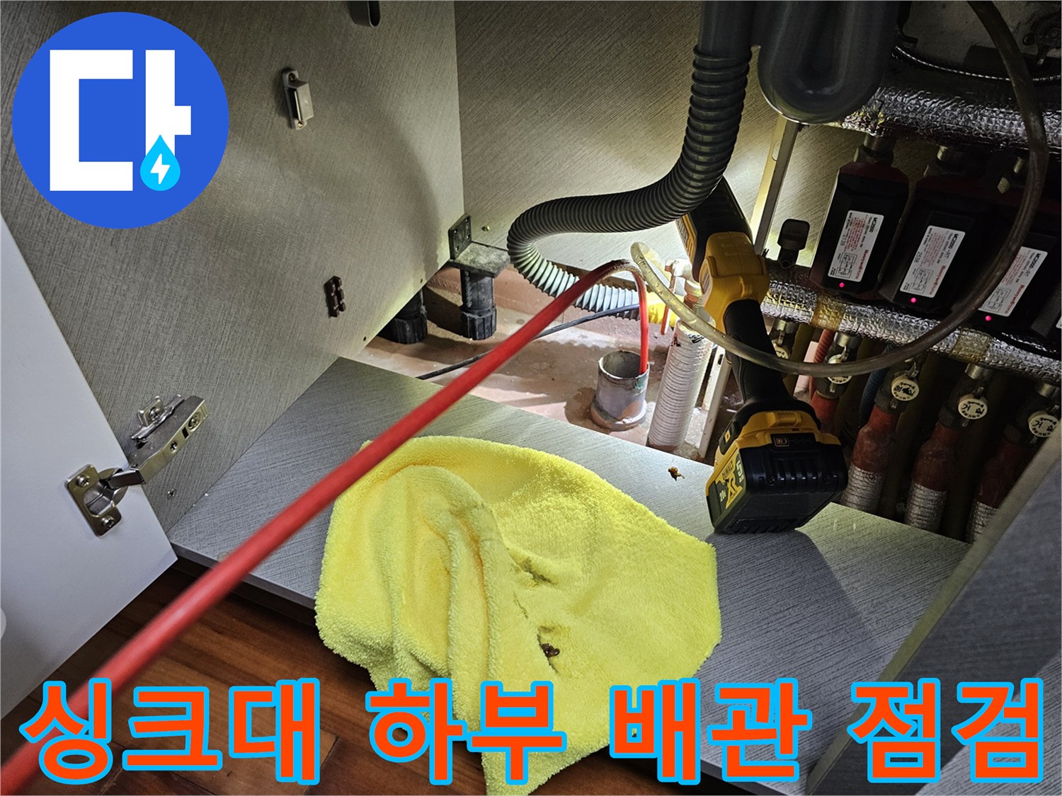 안양 비산동 싱크대 하부장의 복잡한 배관과 분배기 상태를 확인하는 모습