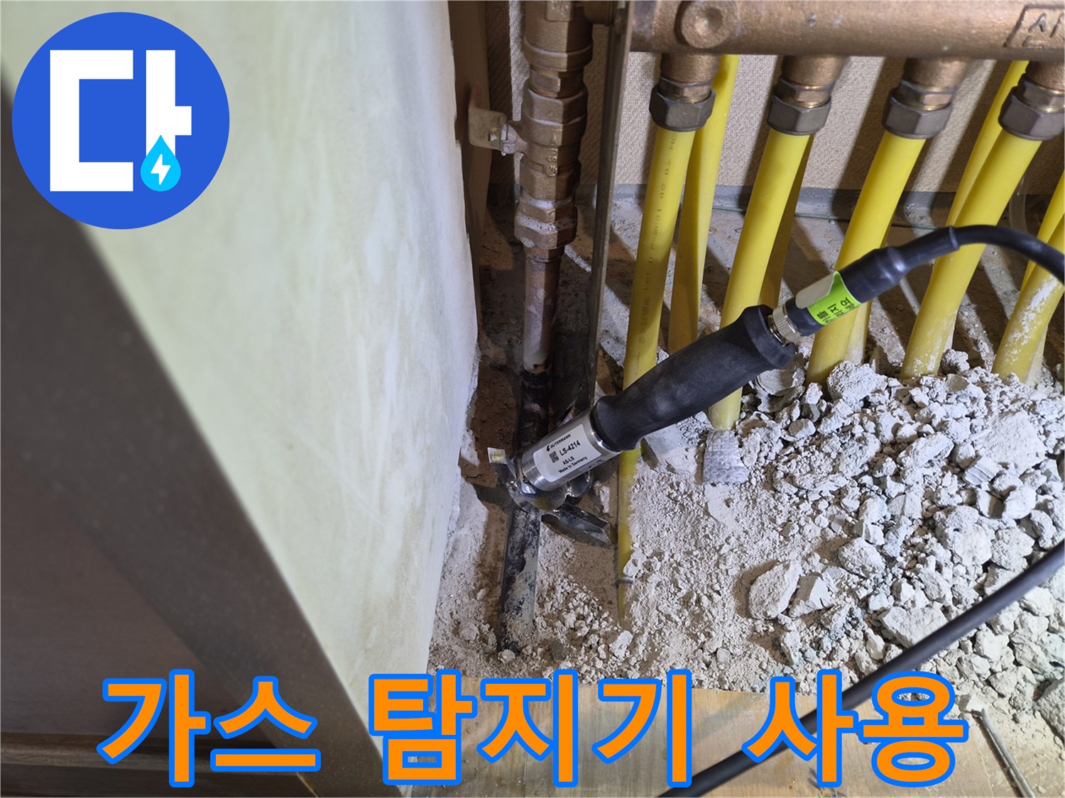 보일러 분배기 근처-누수 위치를 찾기 위해 가스 탐지기를 대조하는 장면