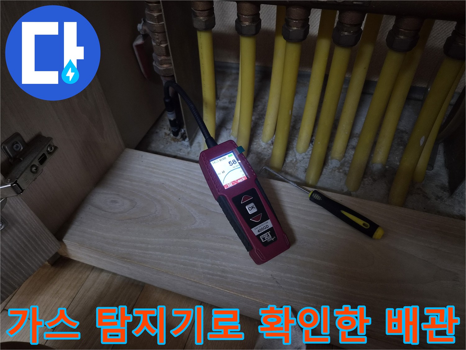 보일러 분배기 부근에서-가스 탐지기를 사용하여-누수 지점을 찾는 모습