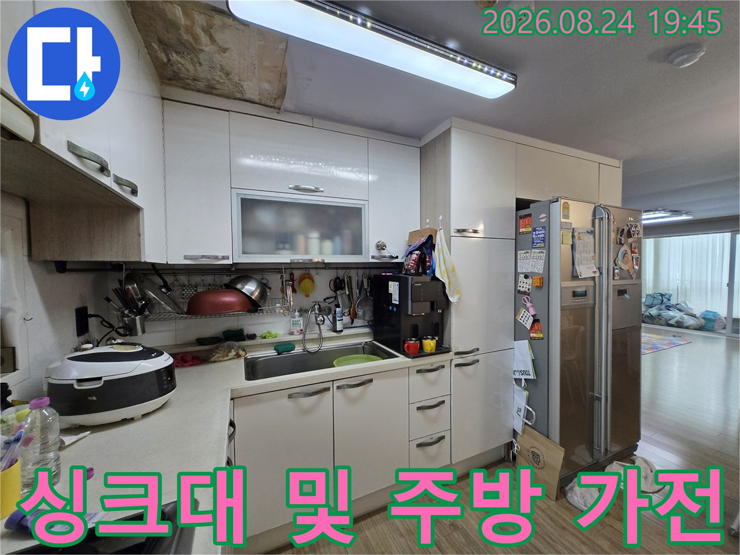 냉장고와 싱크대가 배치된 일반적인 주방 풍경입니다.