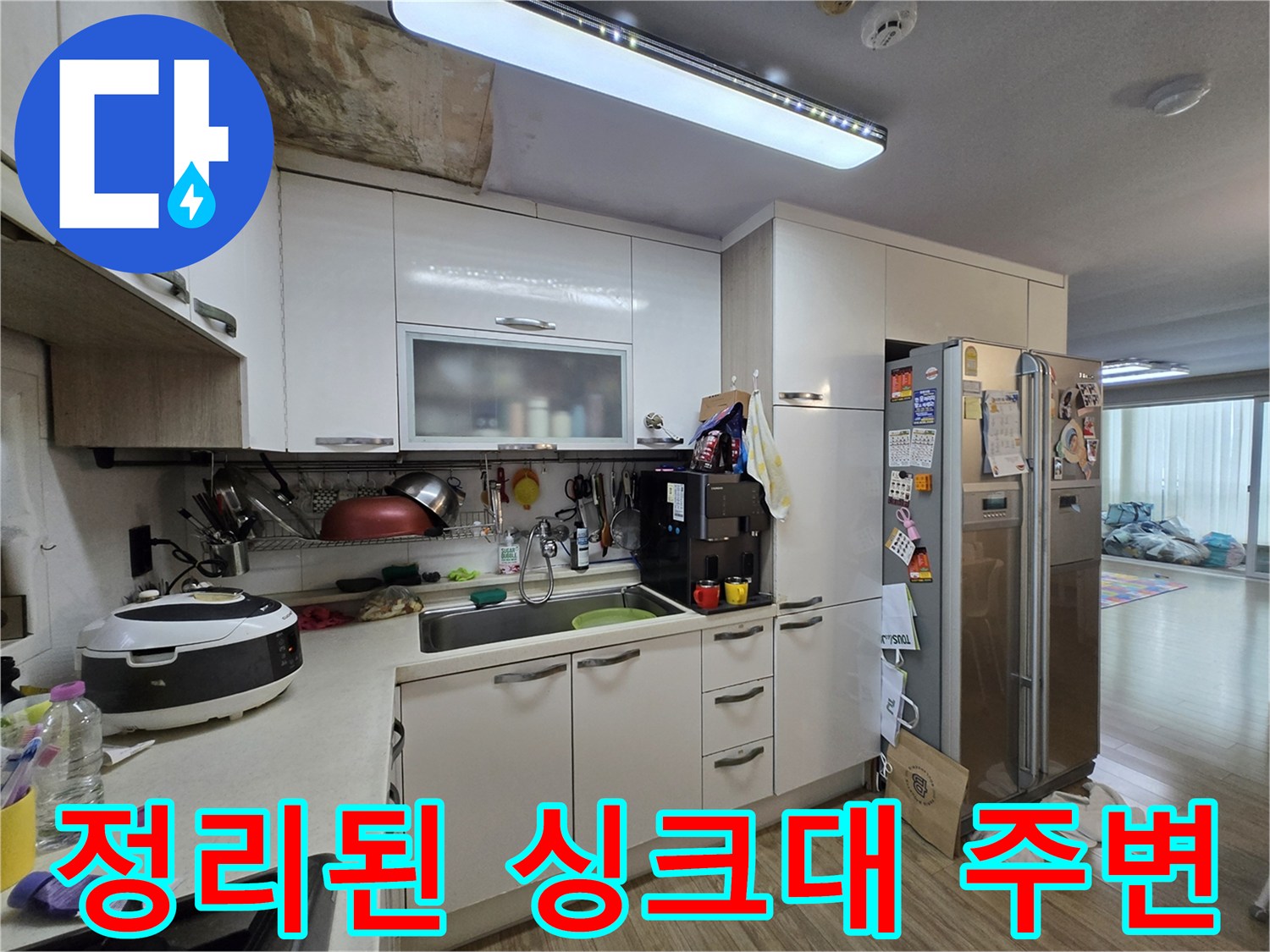 주방 가전과 싱크대가 배치된 일상적인 주방 환경