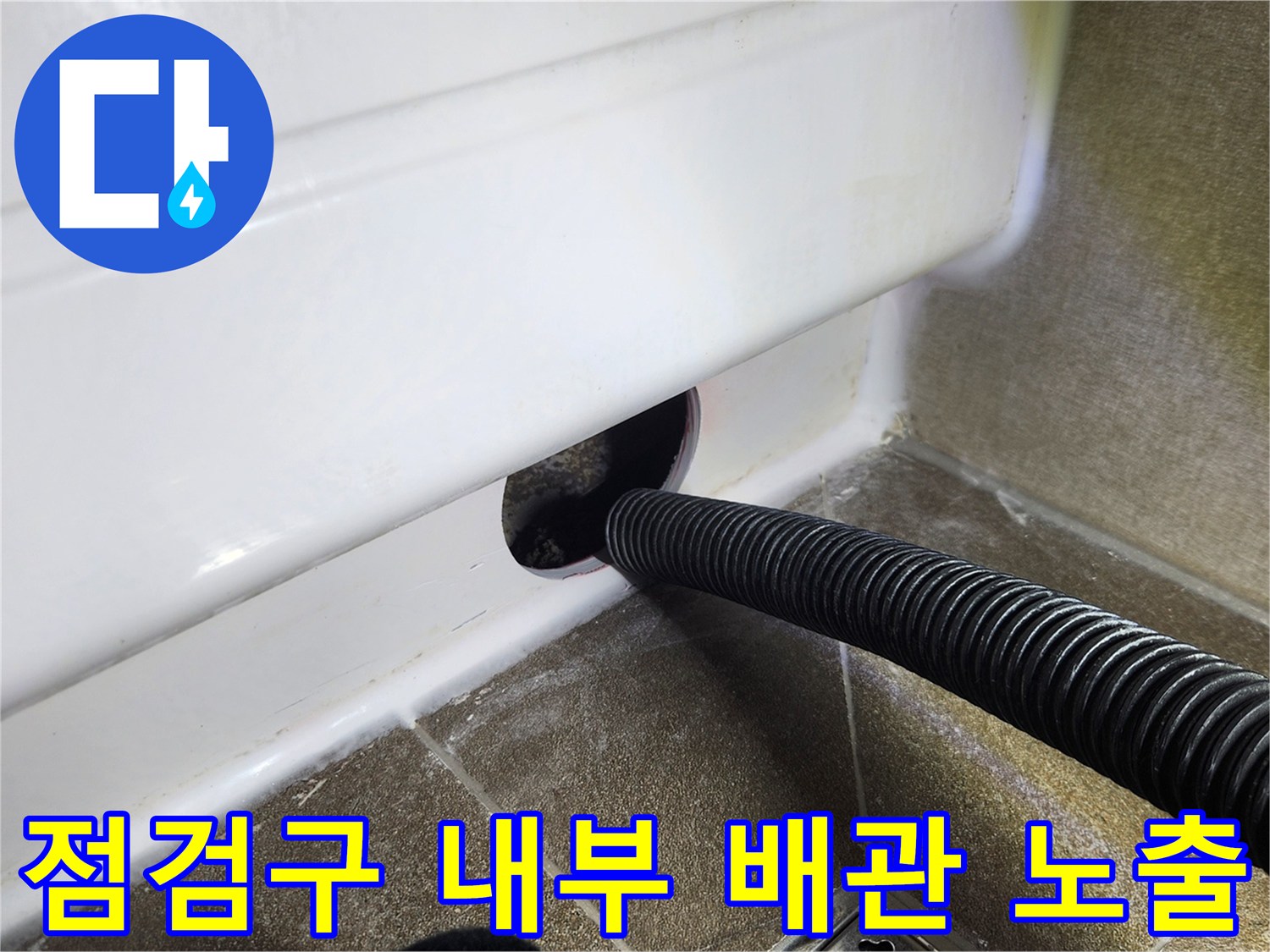 욕조 벽면 하단에 새로 만든 점검구와 주름 호스