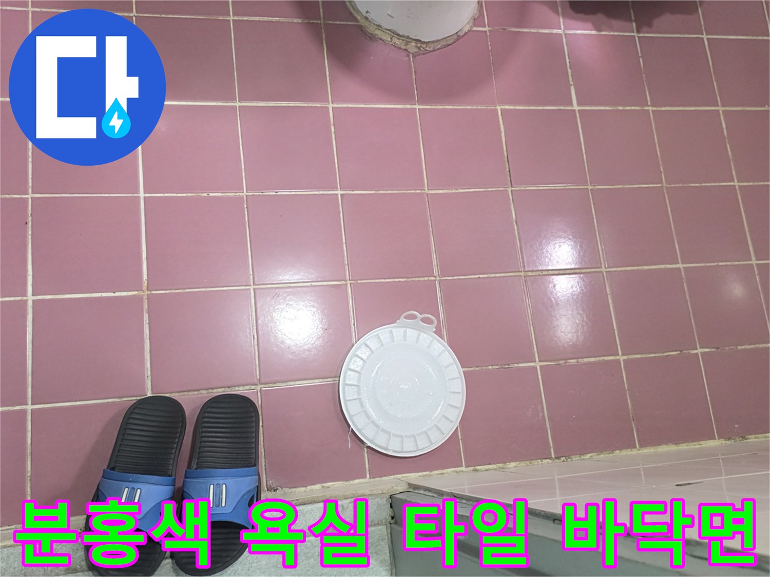 정리된 상태의 분홍색 화장실 타일과 배수구 부품