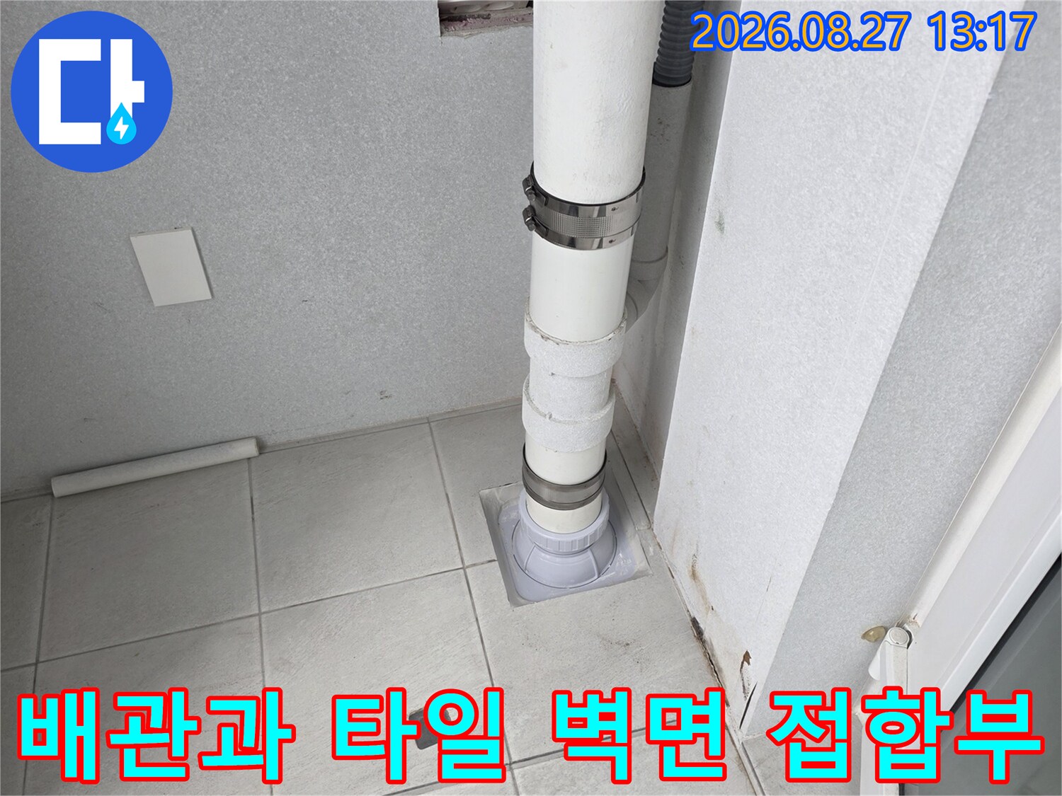 우수관 하얀색 배관이 벽면 타일 안으로 연결된 모습