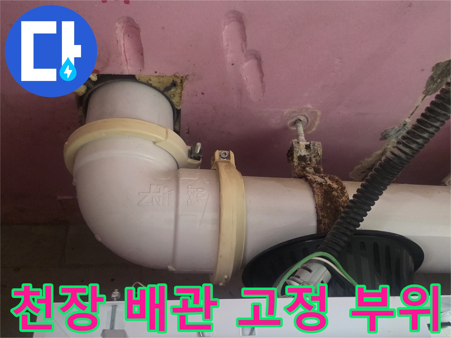 배관을 고정하는 클램프와 연결부 주변의 습한 상태 묘사