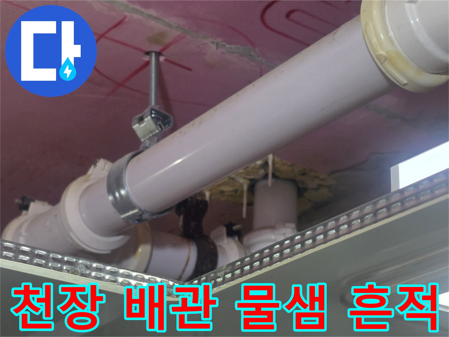 욕실 천장 내부의 PVC 배관-배관 연결부 주위의 젖은 흔적과 습기