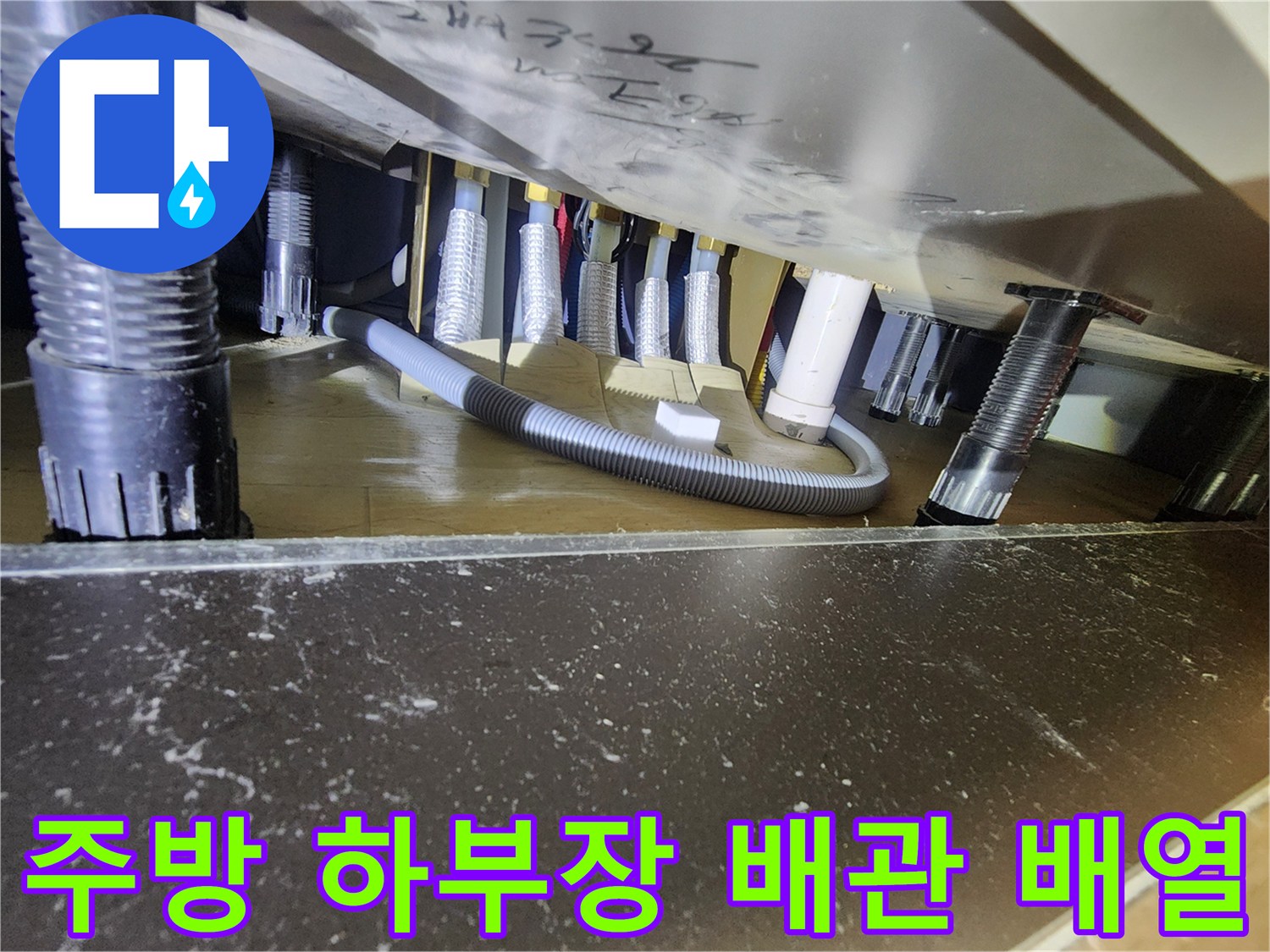 싱크대 밑 공간의 검정색 및 흰색 배관 연결 구조 촬영