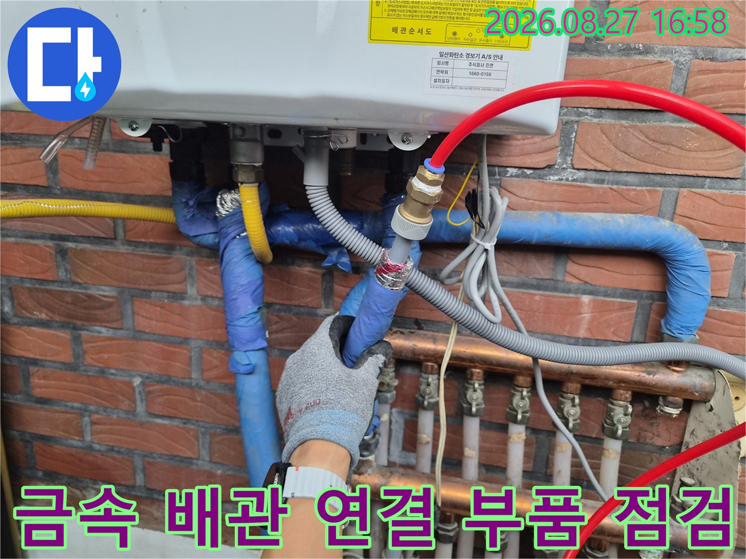 파란색 보온재로 감싸진 배관의 금속 커플러를 만지는 작업 모습