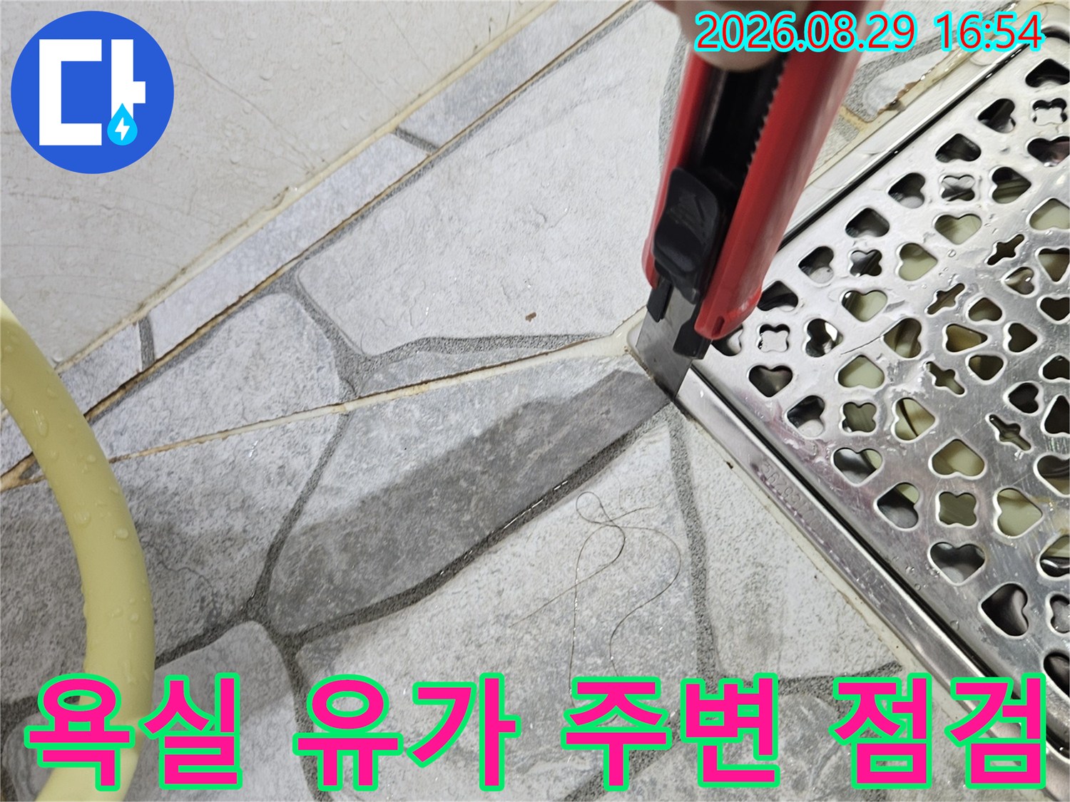 하트 모양 패턴이 있는 스테인리스 배수구와 타일 경계면 촬영
