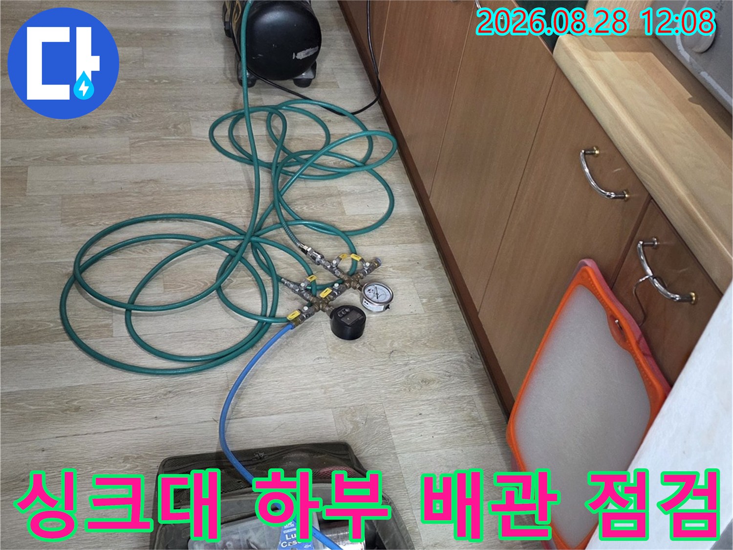 싱크대 아래쪽 공간에 배치된 배관 압력 측정 장비와 연결 호스