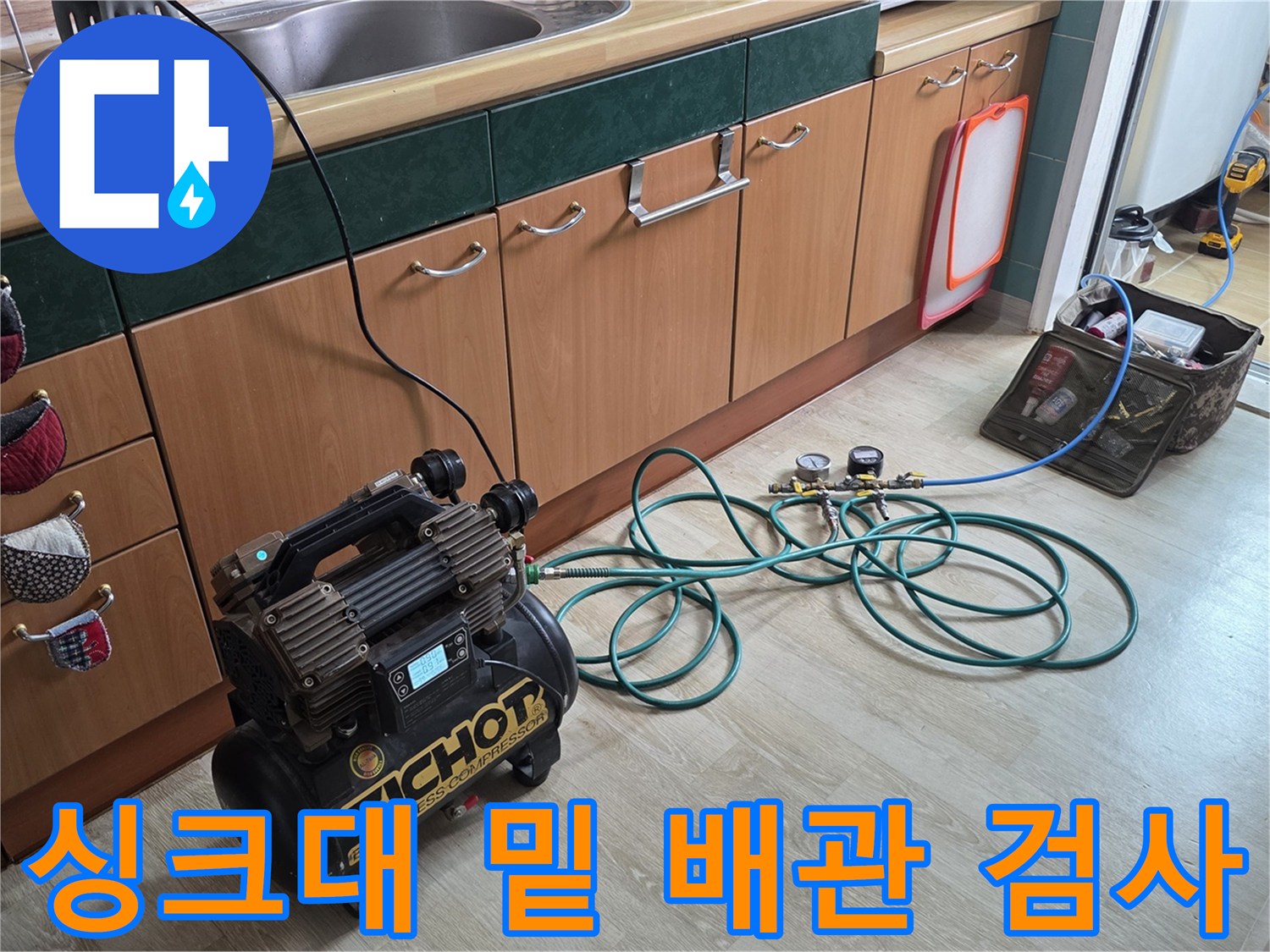 싱크대 하부장 아래 설치된 공압 테스트용 컴프레셔와 연결 호스