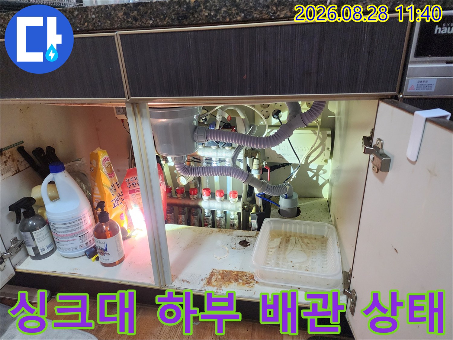 남양주 진접읍 싱크대 하부장 내부의 복잡한 배관과 에어컨 드레인 호스 연결 부위 모습