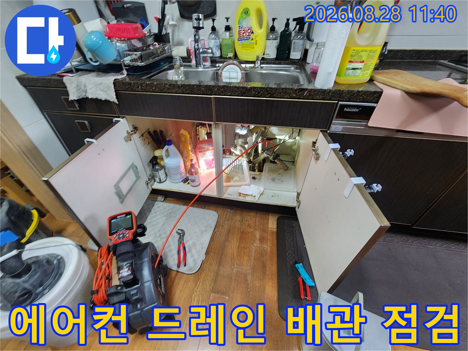 싱크대 하부 배관 연결 부위와 누수 탐지용 장비의 모습
