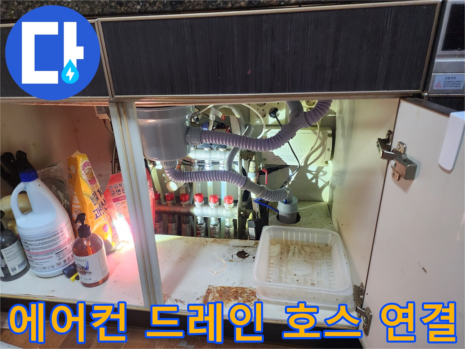 싱크대 하부장 내부의 에어컨 응축수 배출용 자바라 호스와 분기된 배관들