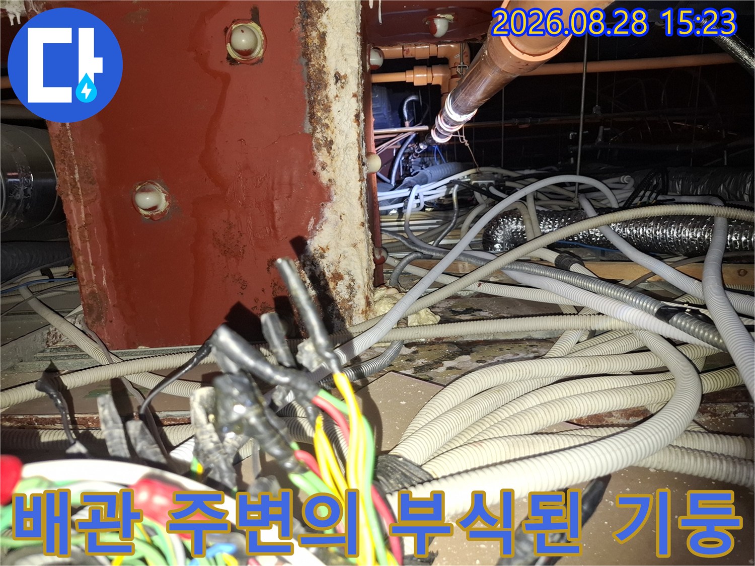 습기에 노출되어 변색된 붉은색 기둥과 배관 시설물