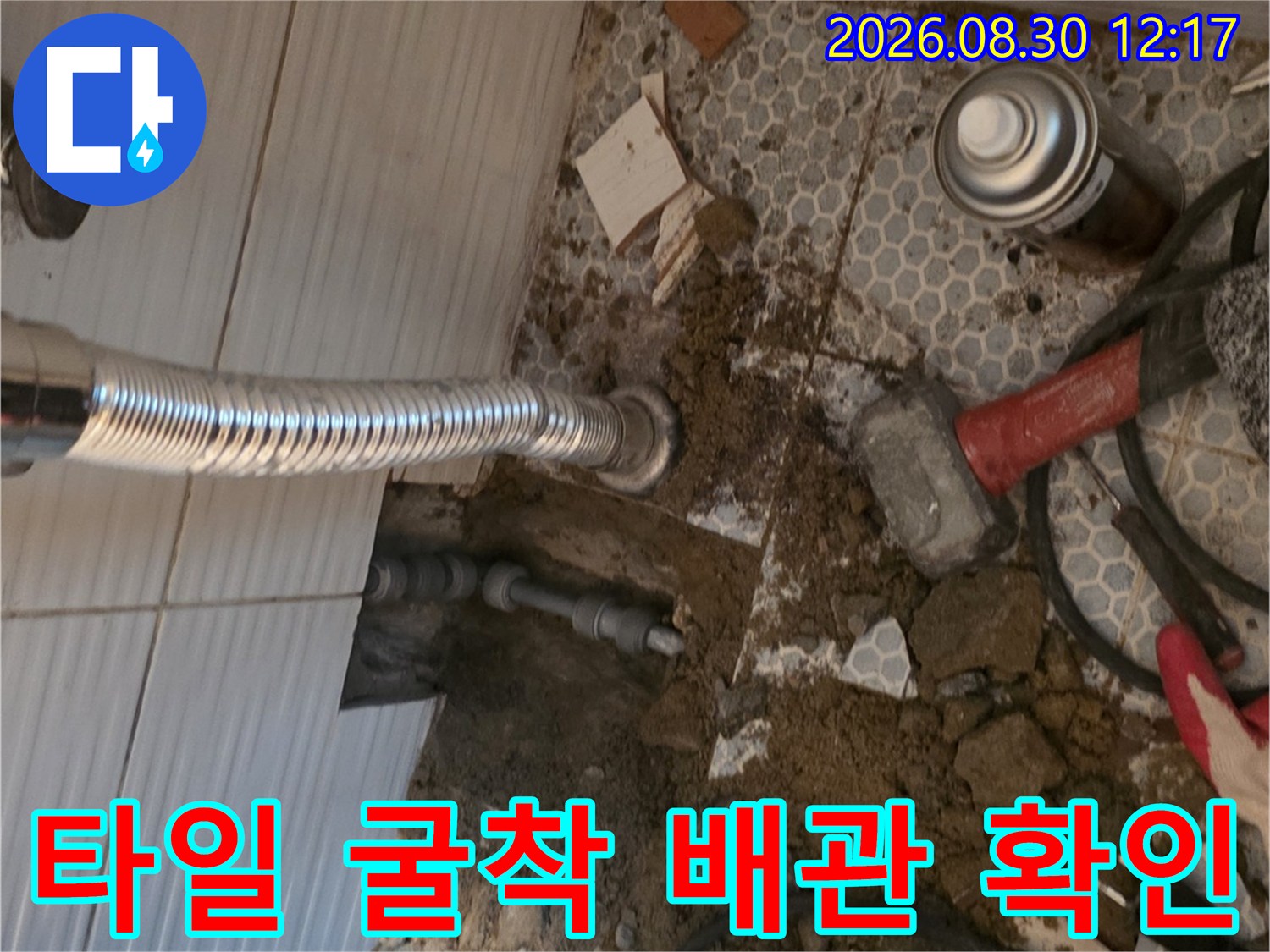 세면대 아래 타일을 제거하고 매립 배관을 드러낸 작업 사진