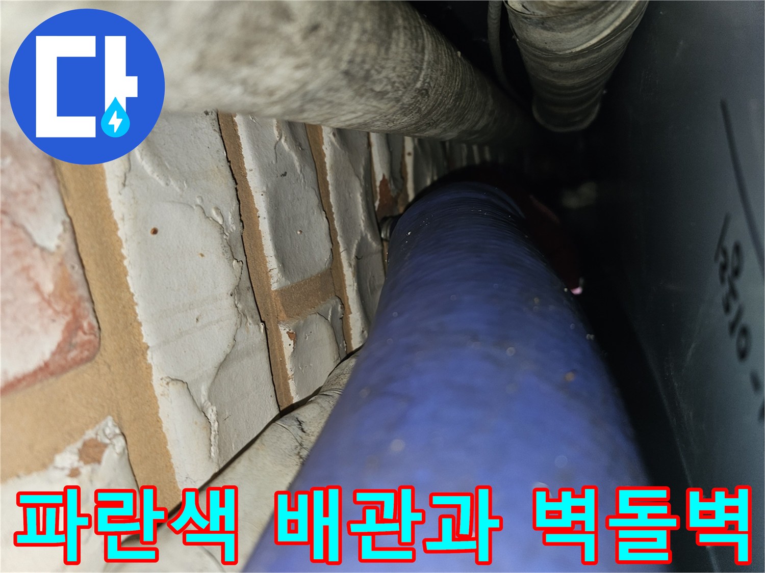 벽돌 벽면 옆에 배치된 파란색 급수 배관 촬영