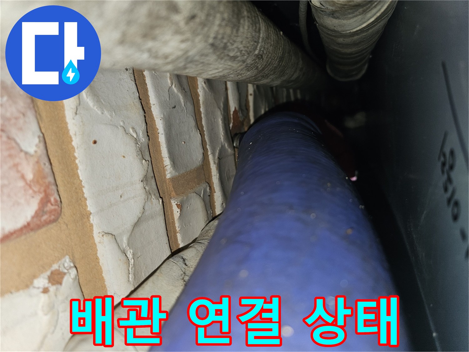 벽돌 벽면과 파란색 배관의 접합 부위 근접 촬영