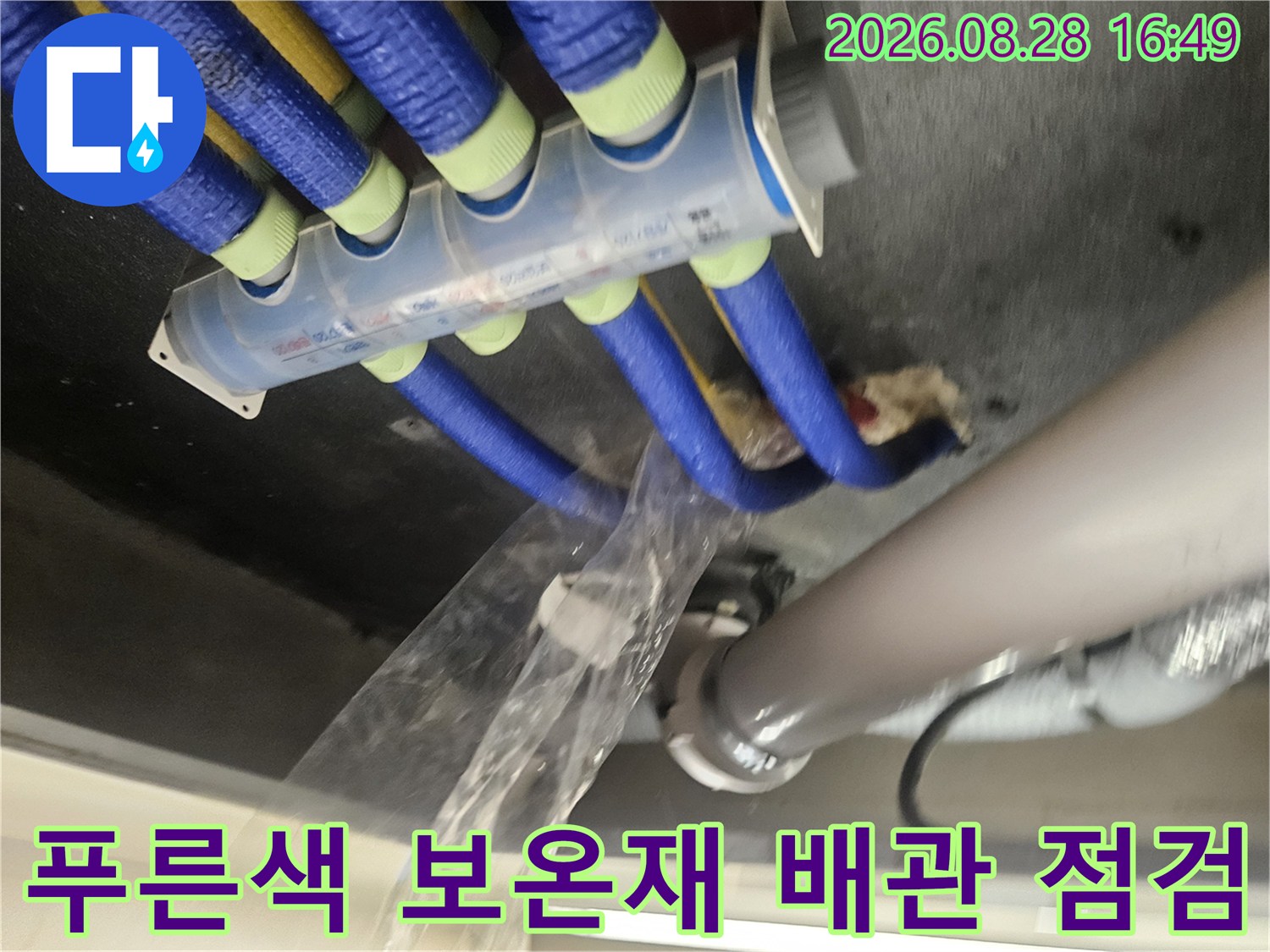 천장 내부의 푸른색 보온재로 감싸진 다수의 급수 및 배수 배관들