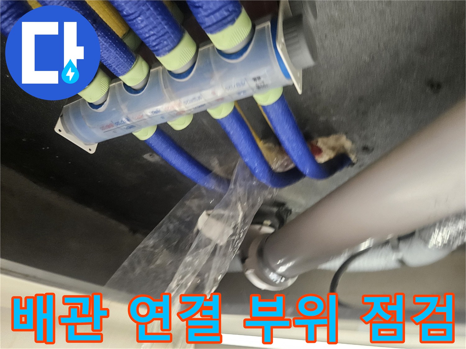 파란색 보온재로 감싸진 배관과 흰색 PVC 파이프가 만나는 지점
