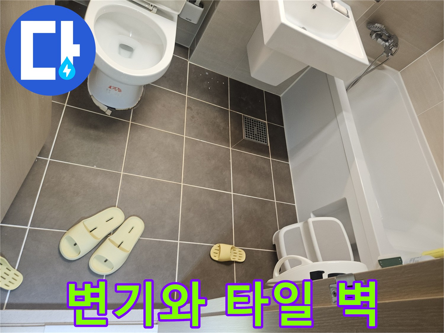 화장실의 양변기와 회색 타일 벽면 이미지