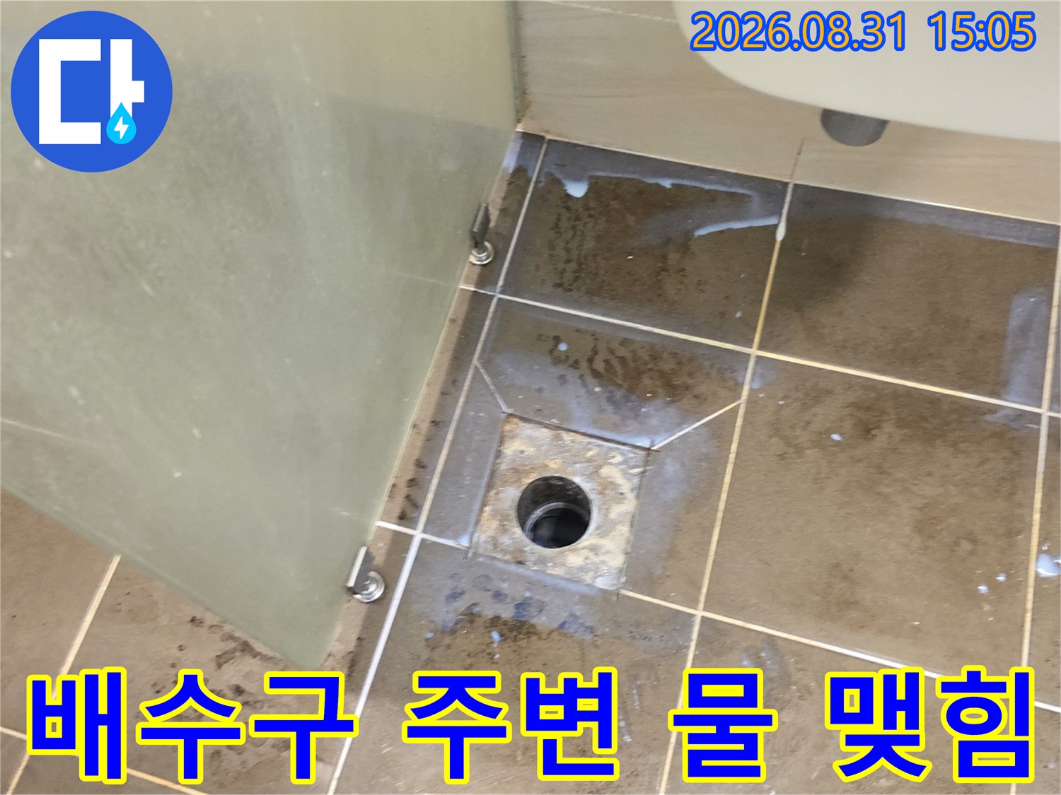 화장실 배수구 유가 근처에 물기가 스며든 타일 사진