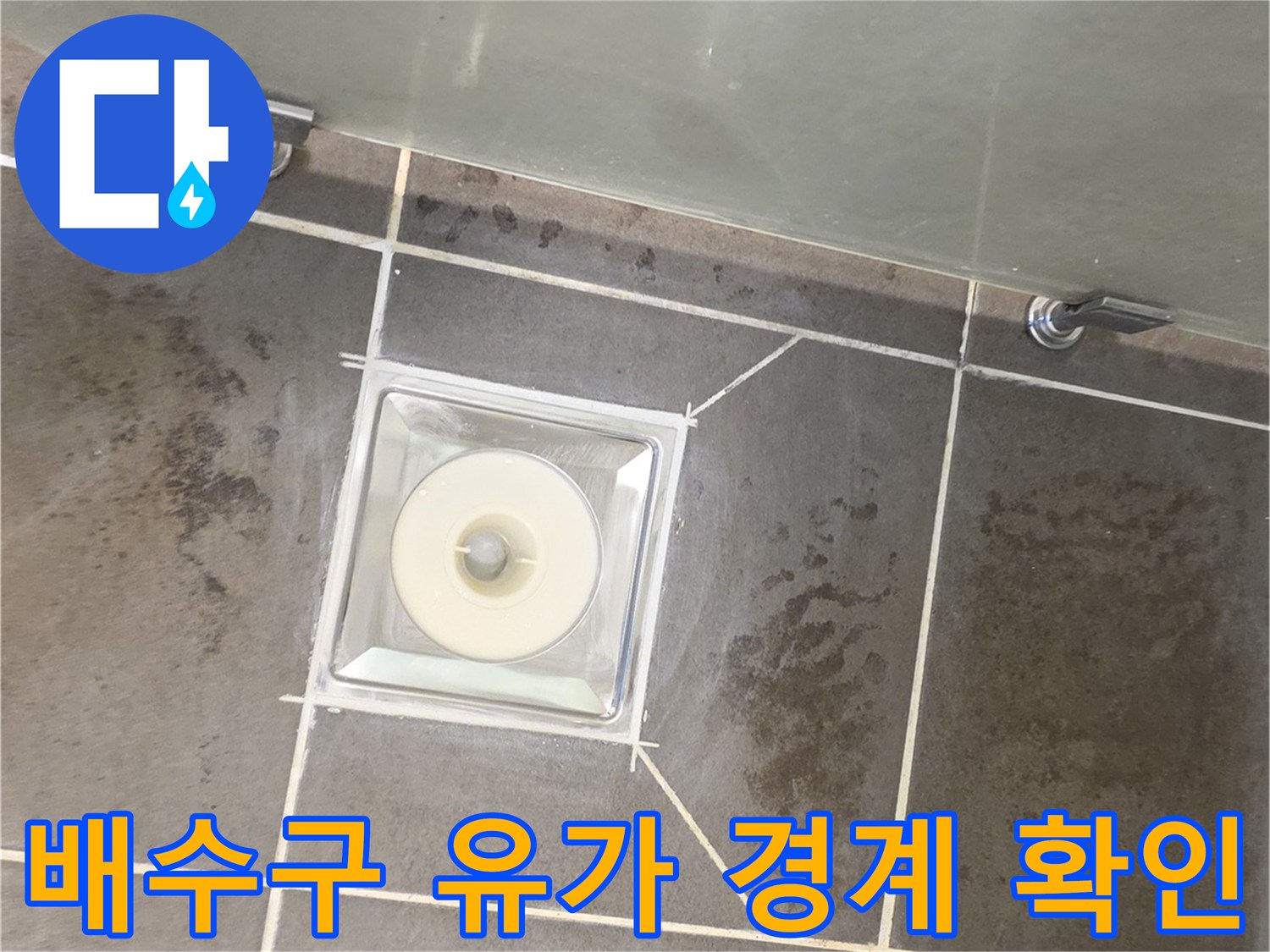 화장실 배수구 유가와 타일이 만나는 경계 부위를 근접 촬영한 사진