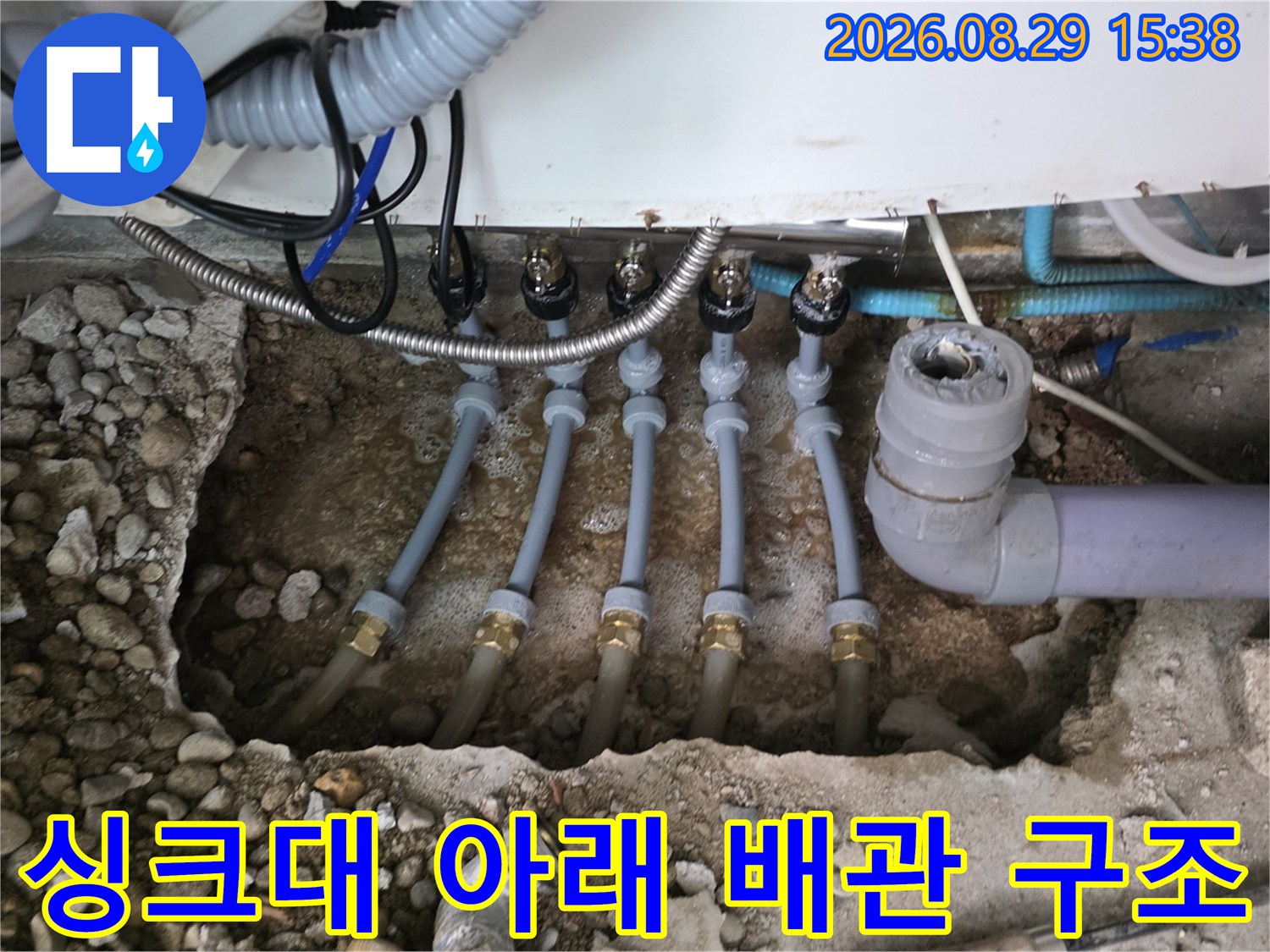 싱크대 하부장 아래 노출된 분배기 및 연결 배관들