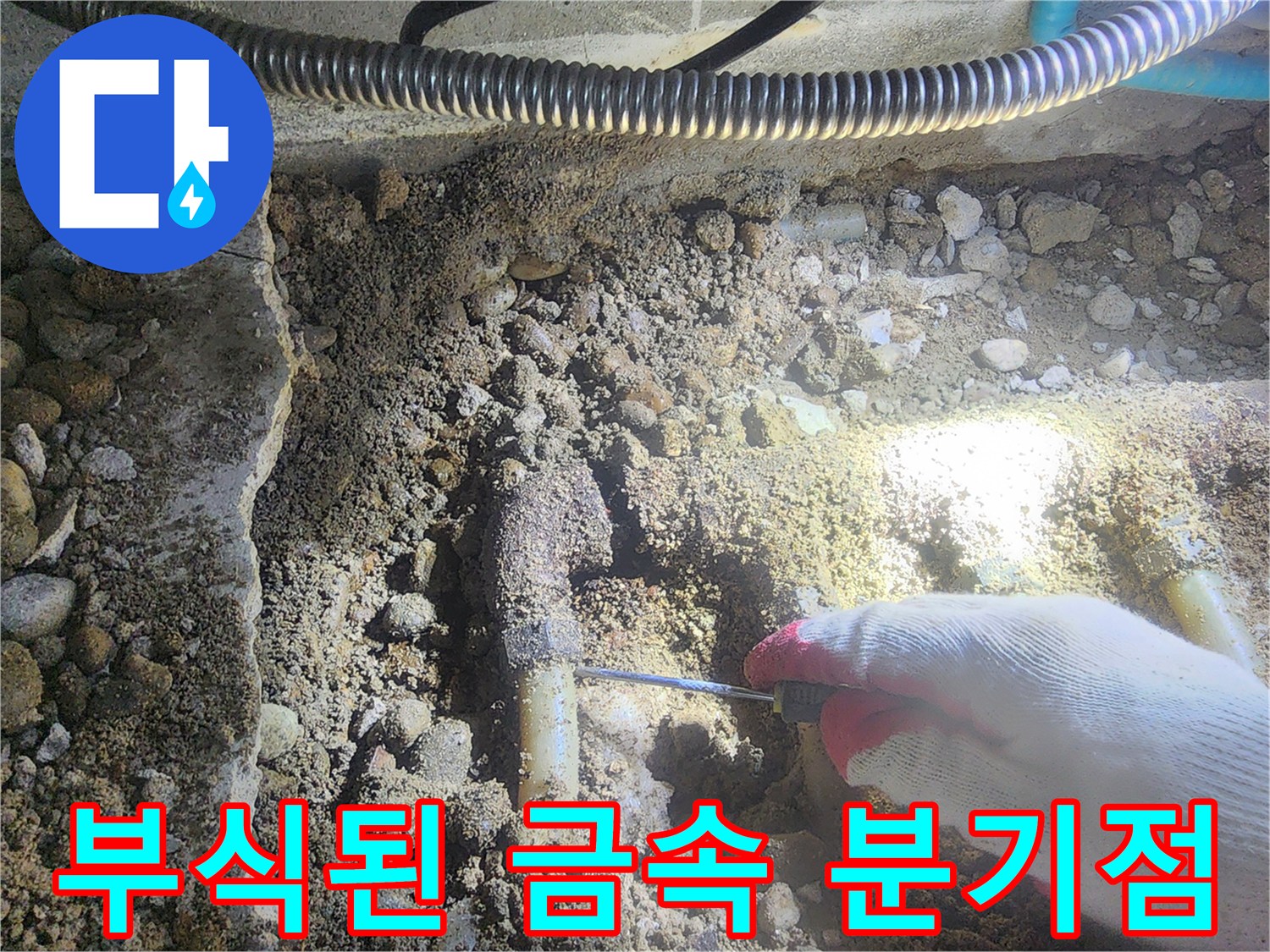 흙더미 아래에서 발견된 부식된 배관 연결부