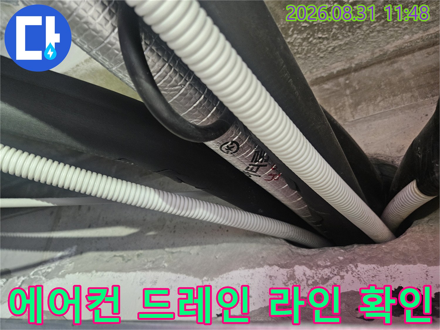 천장 내부의-검은색 보온재와-하얀색 주름관이 연결된 배관 모습
