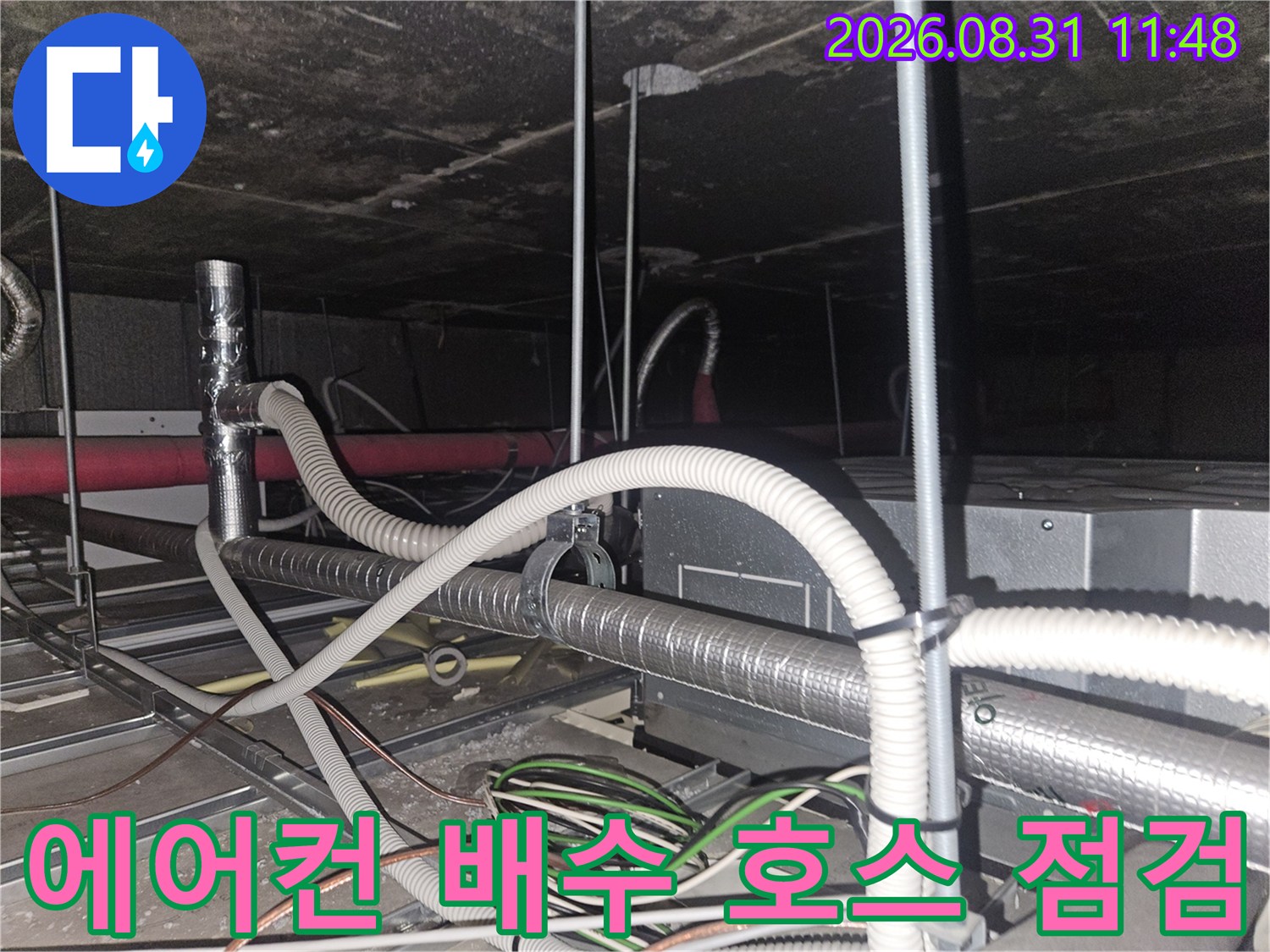 천장 내부의 에어컨 드레인 관로와 은색 보온재가 씌워진 배관
