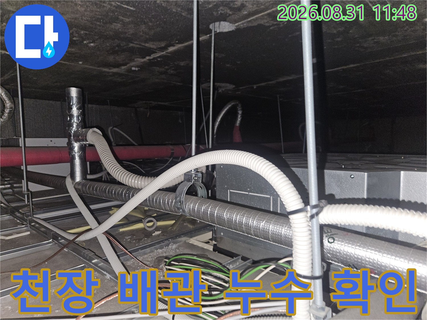 천장 내부의 에어컨 드레인 호스와 은색 보온재로 감싸진 배관 구조