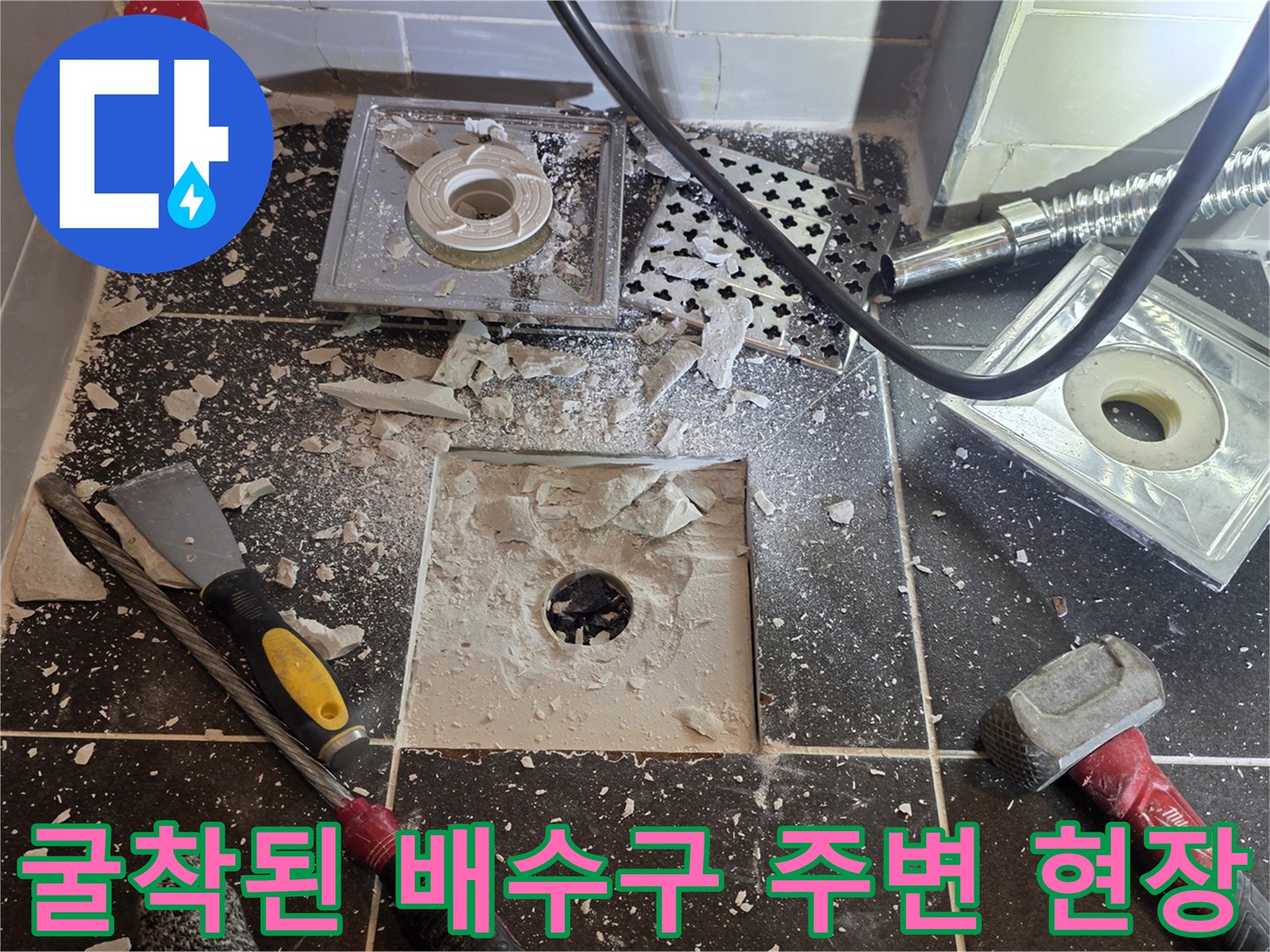 배관-주변의-타일-파편과-노출된-하수구-입구