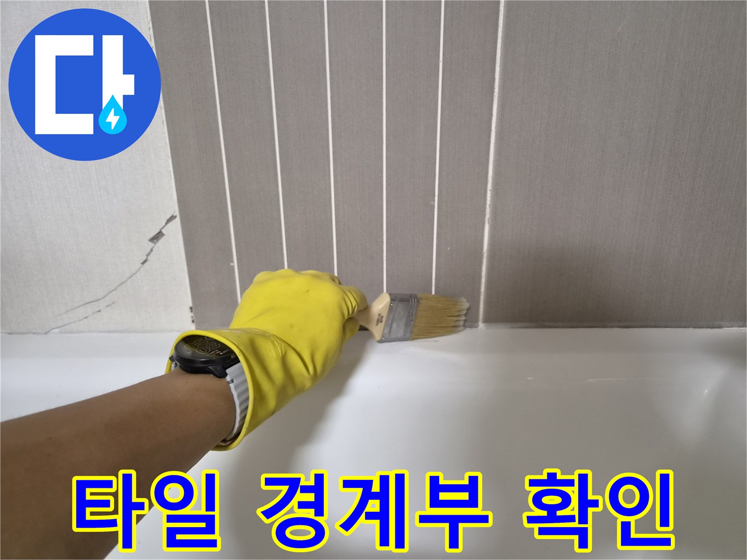 노란 장갑을 낀 작업자가 브러시로 타일 줄눈 부위를 닦아내는 장면