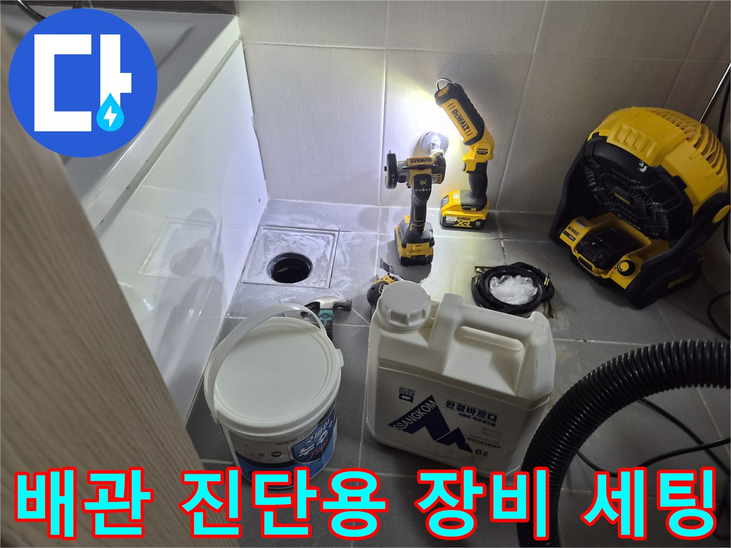 배수구 주변에 놓인 청소 장비와 드릴 공구
