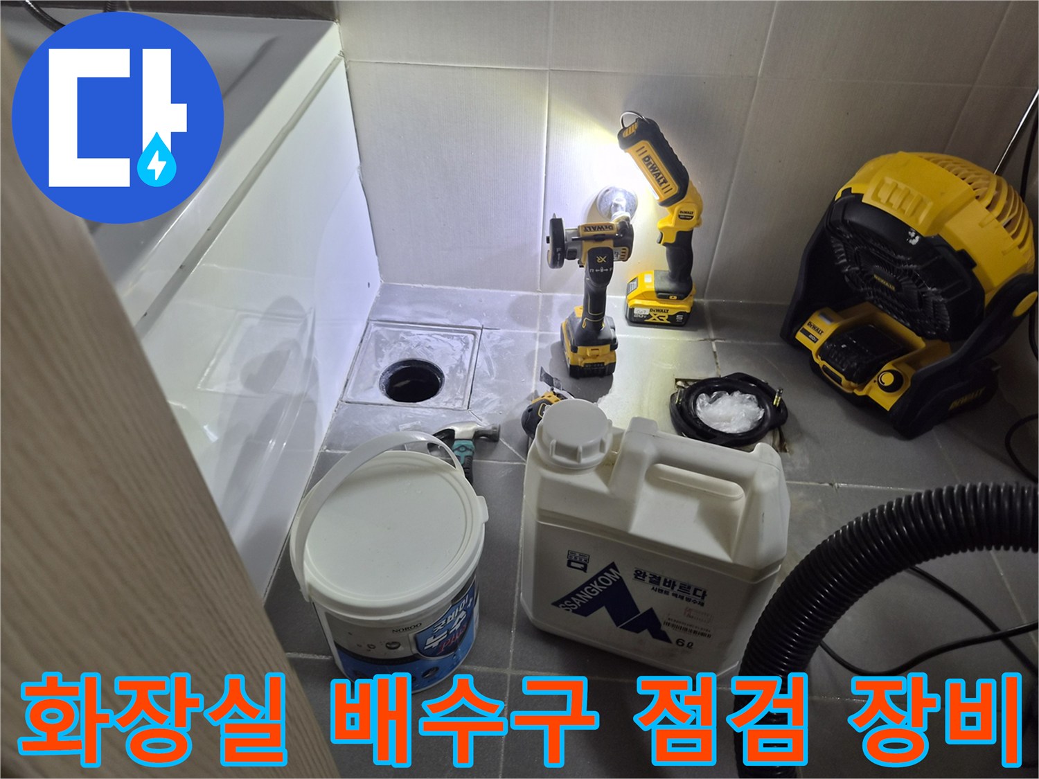 화장실 배수구 주변의 누수를 확인하기 위해 배치된 전동 드릴과 작업 도구들