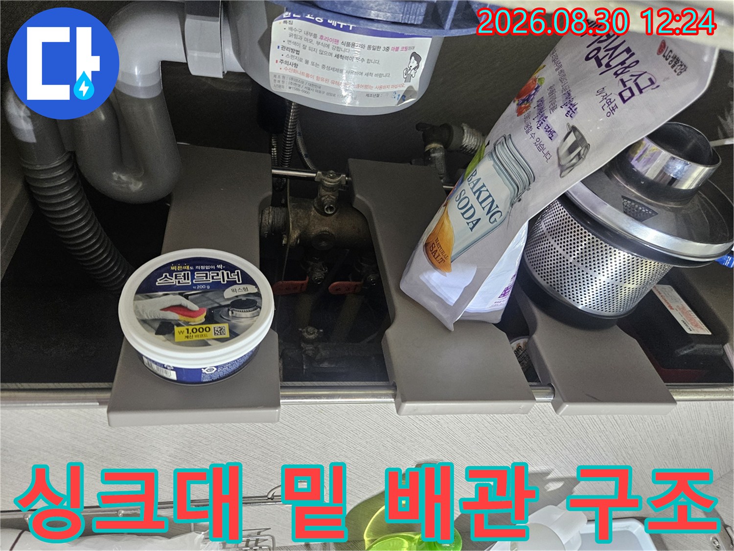 싱크대 하부장의 굵은 배관과 배수 호스 연결 구조물