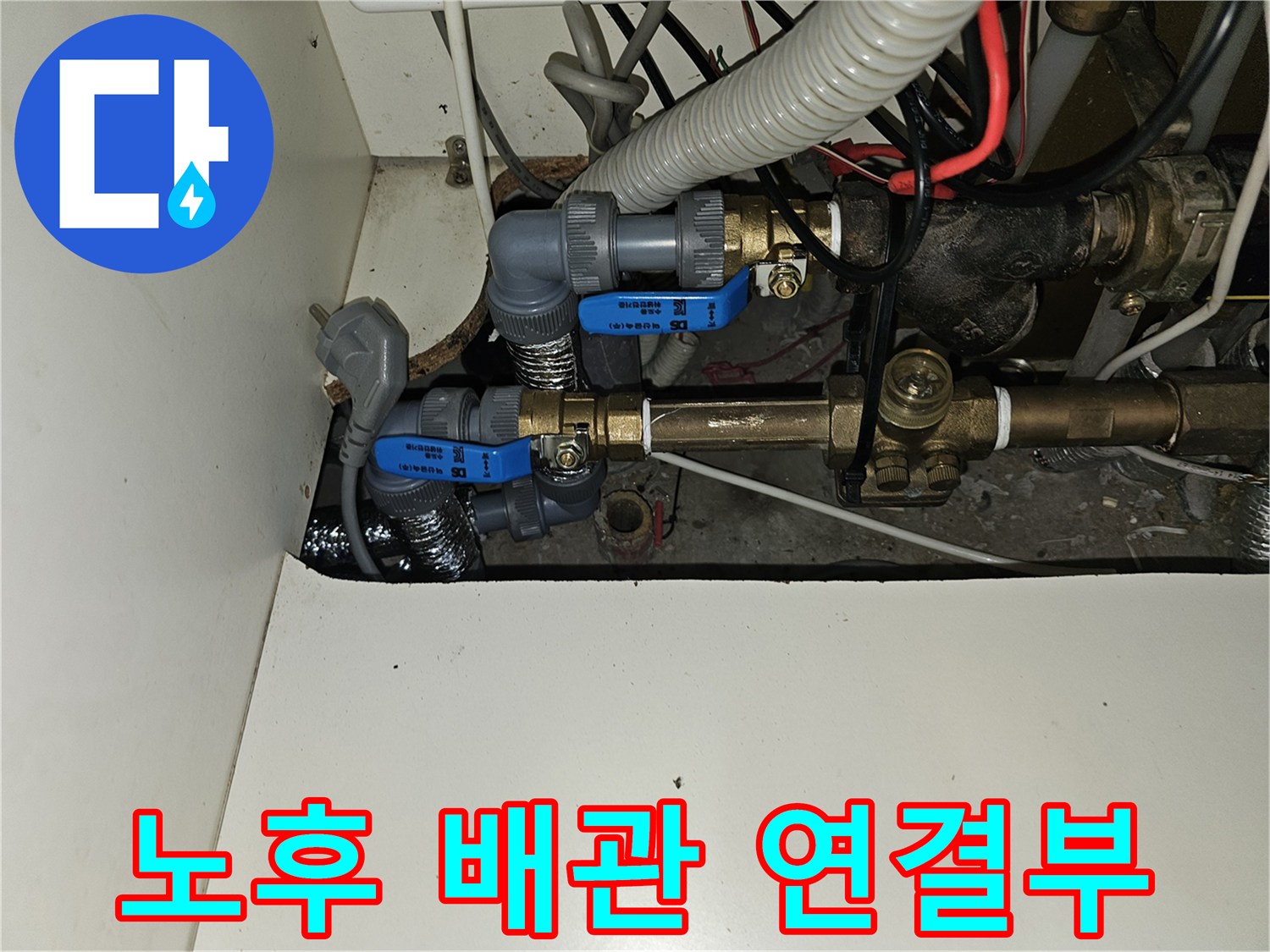 난방 분배기에 연결된 금속 관과 밸브 부속들의 상세 사진