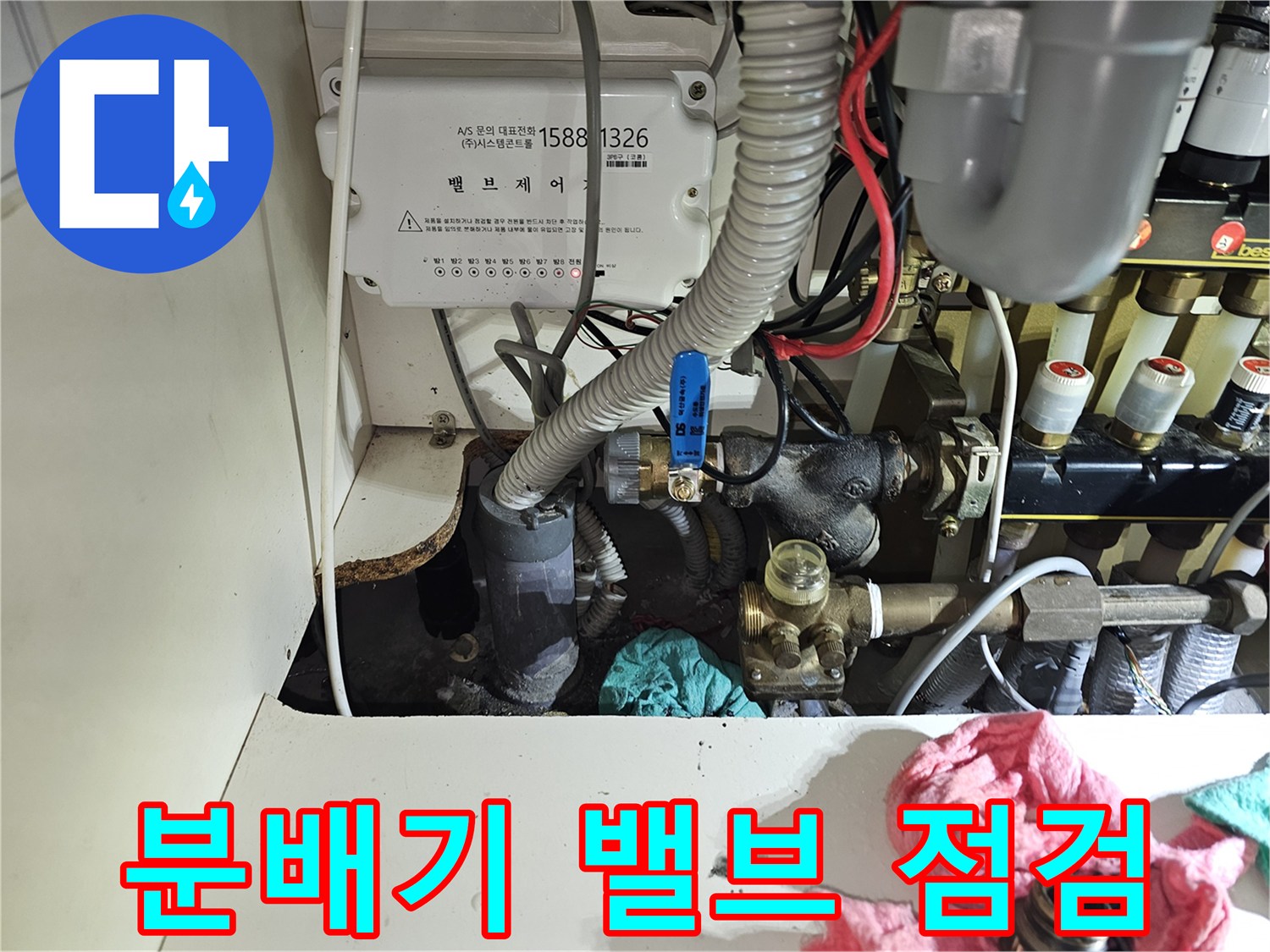 난방 분배기의 파란색 밸브와 연결된 배관의 상세한 모습입니다.