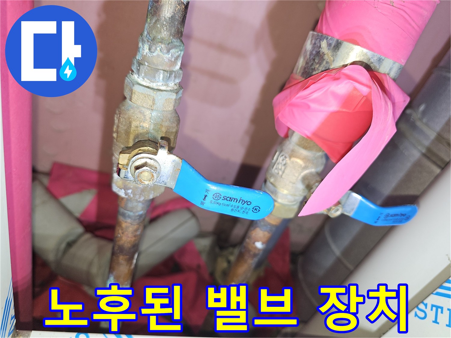 부식된 금속 배관과 파란색 조절 밸브의 근접 촬영